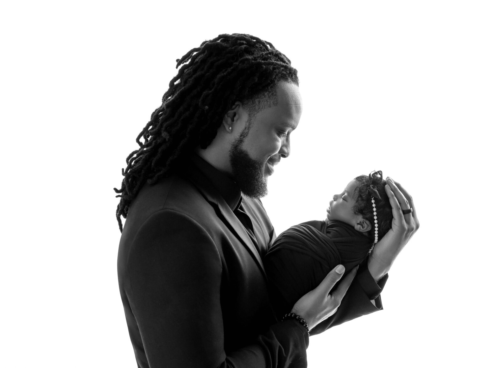 B&W portrait of Dad looking at his newborn baby girl. Photographed by Jenni Nikki Photography at Marietta Newborn Photo Studio.