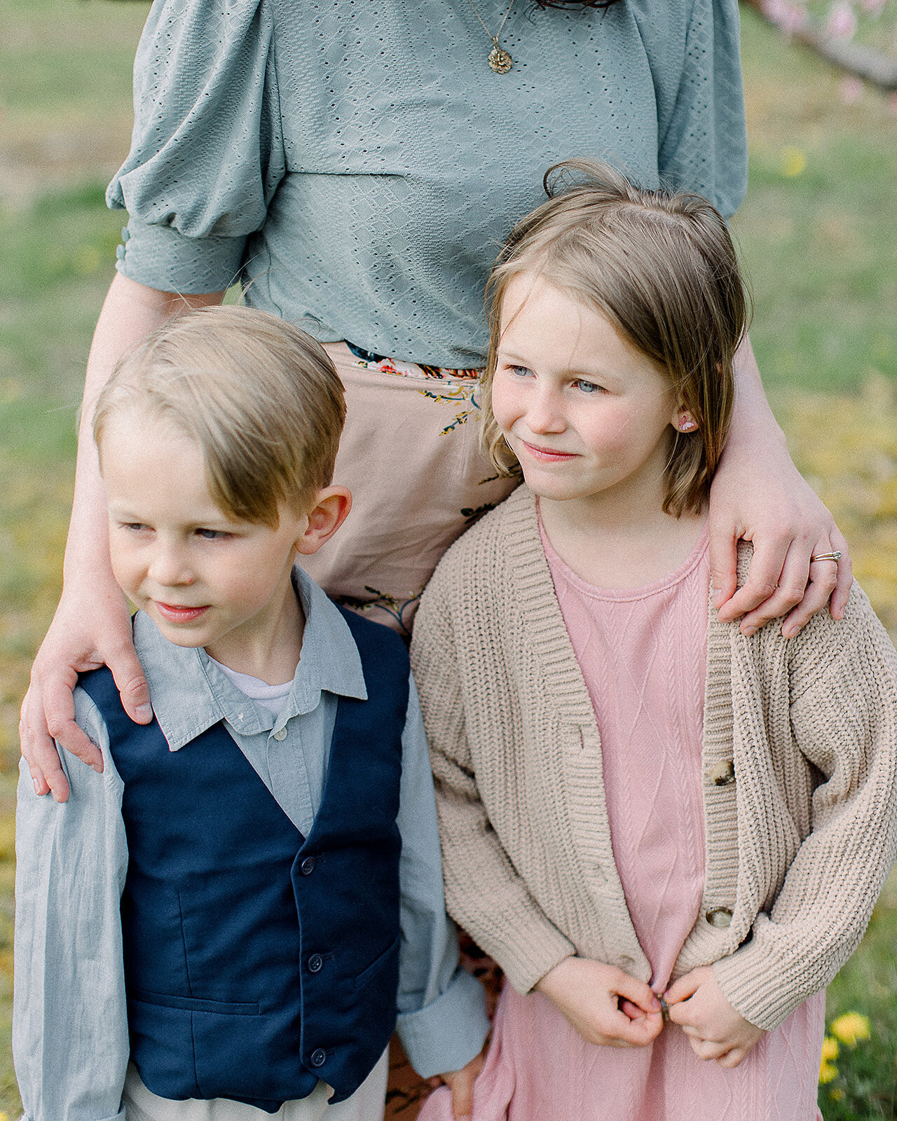 Siblings with their mother in a spring apple orchard by NH newborn photographer Fieldstone Studio.