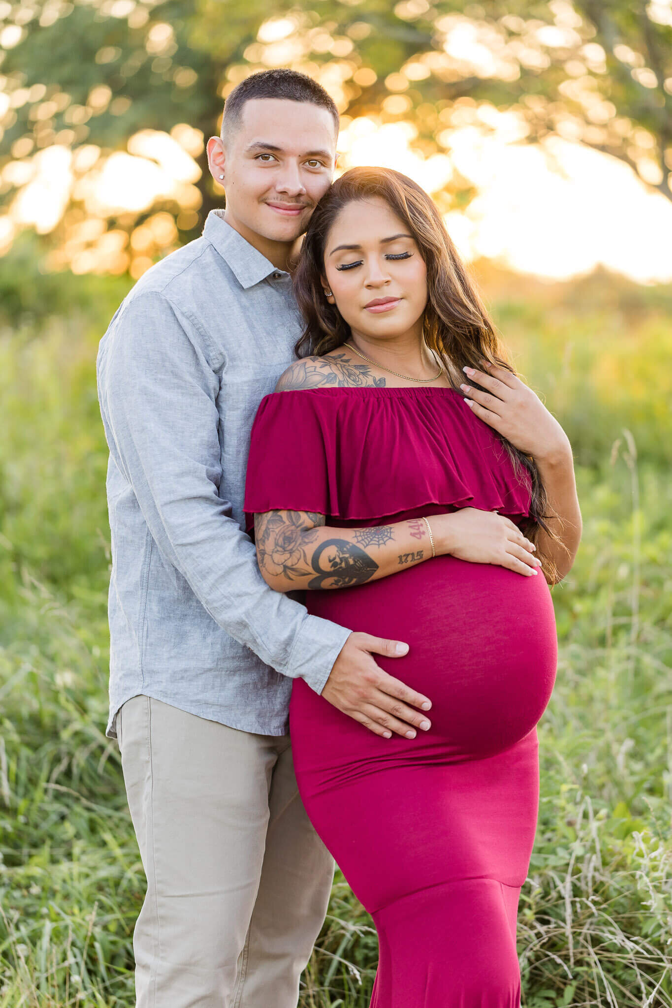 An expecting couple snuggled up together at a Northern Virginia field at sunset.