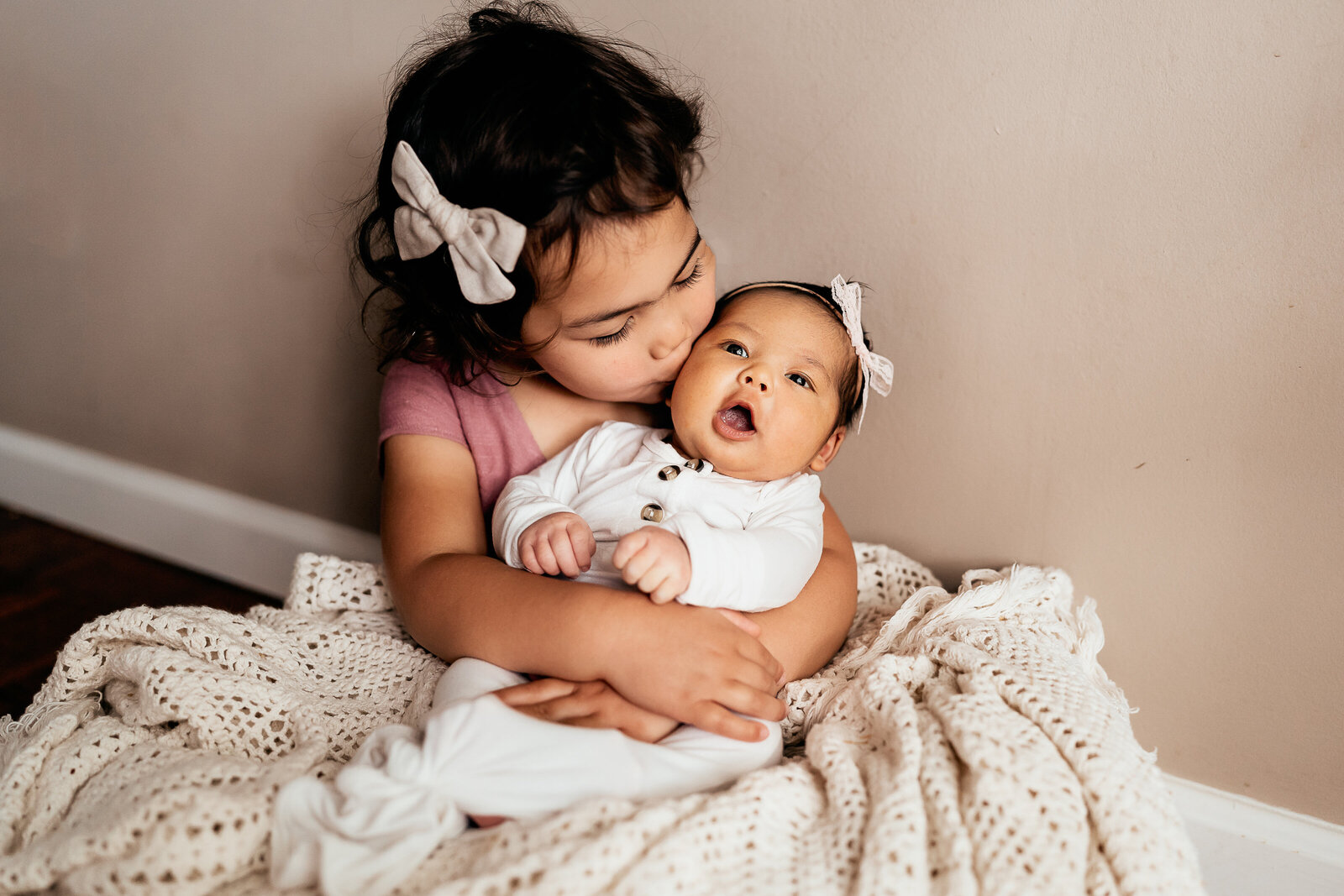 little girl holding baby sister
