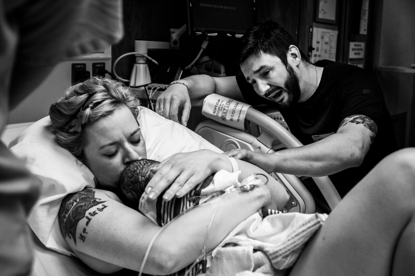 mom holds baby while dad reaches hand out