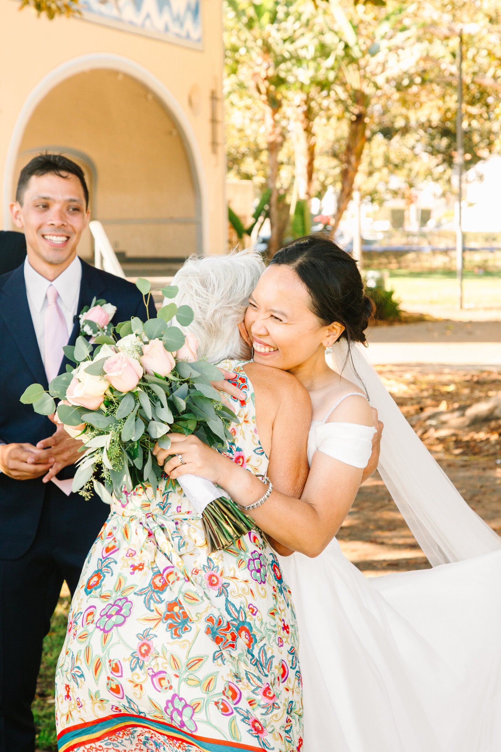 A happy bride hugs her mother in law after the wedding cermeony.