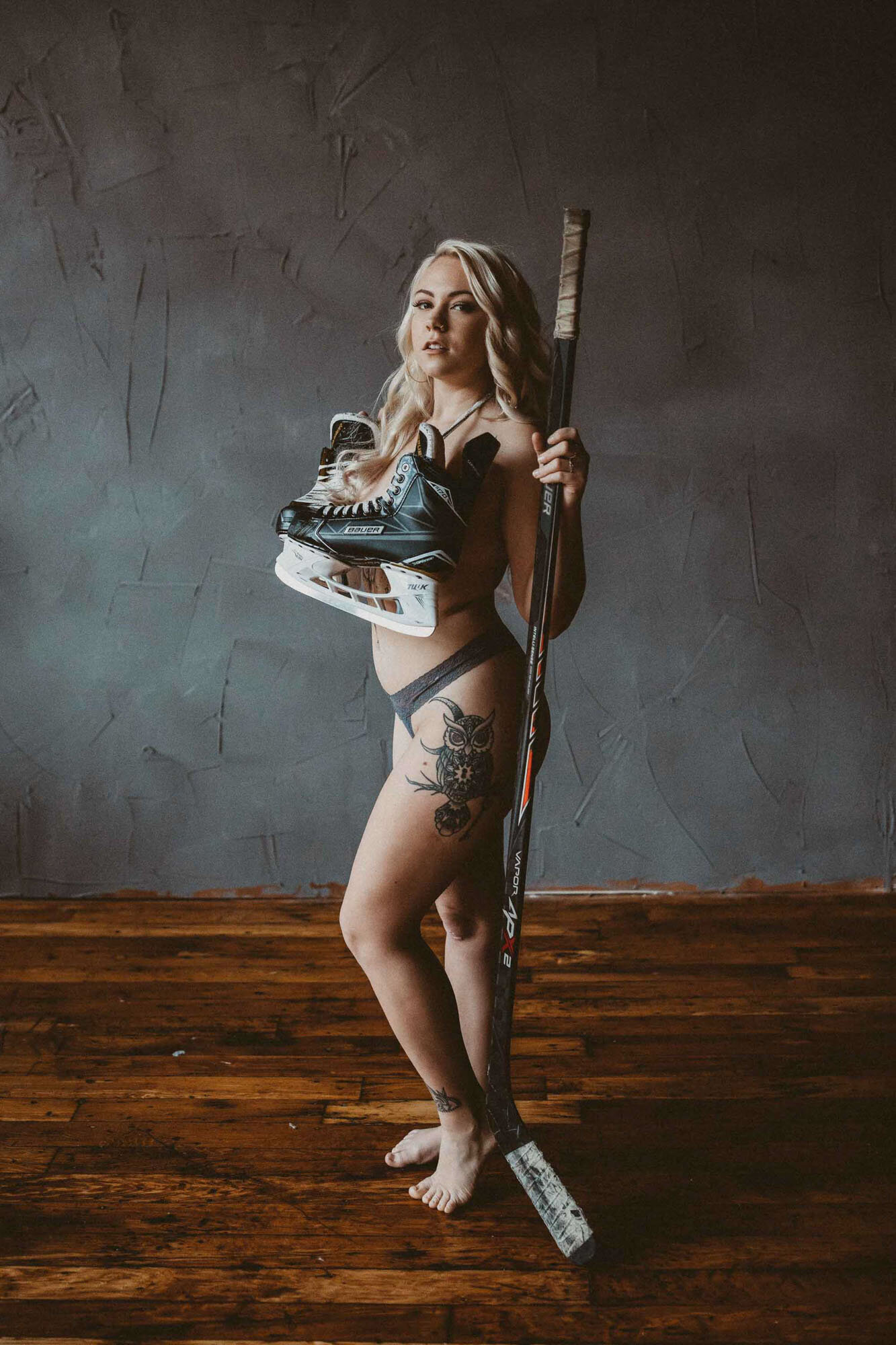 woman with a tattoo on her thigh holding a skate shoes 