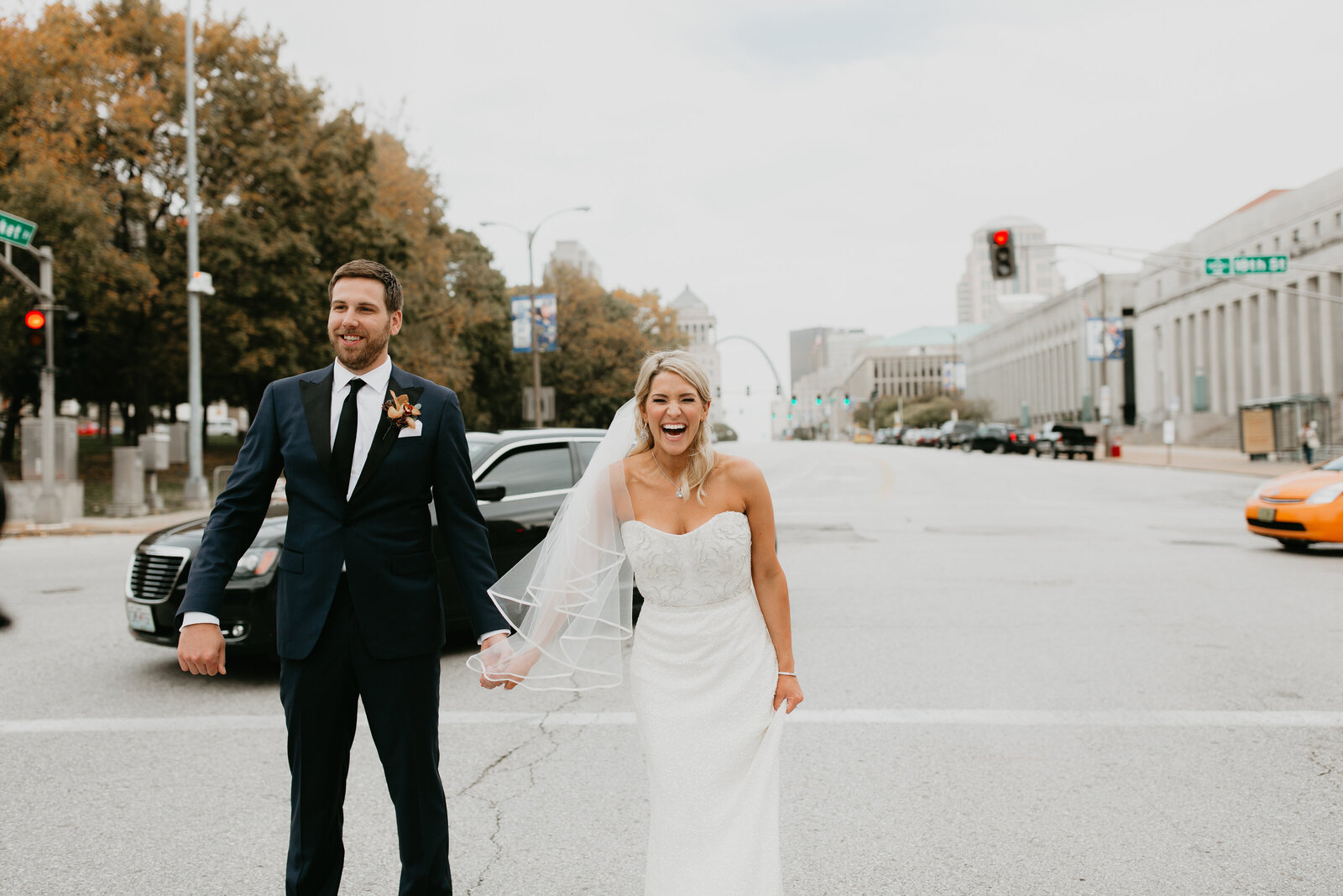 A  wedding portrait of a blonde bride and brunette groom standing in street outside of Union Station in St. Louis, Missouri