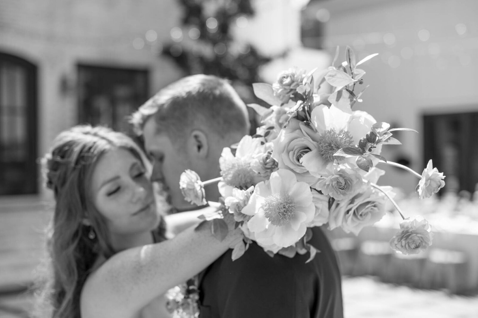 Black and white photo of bride and groom facing each other