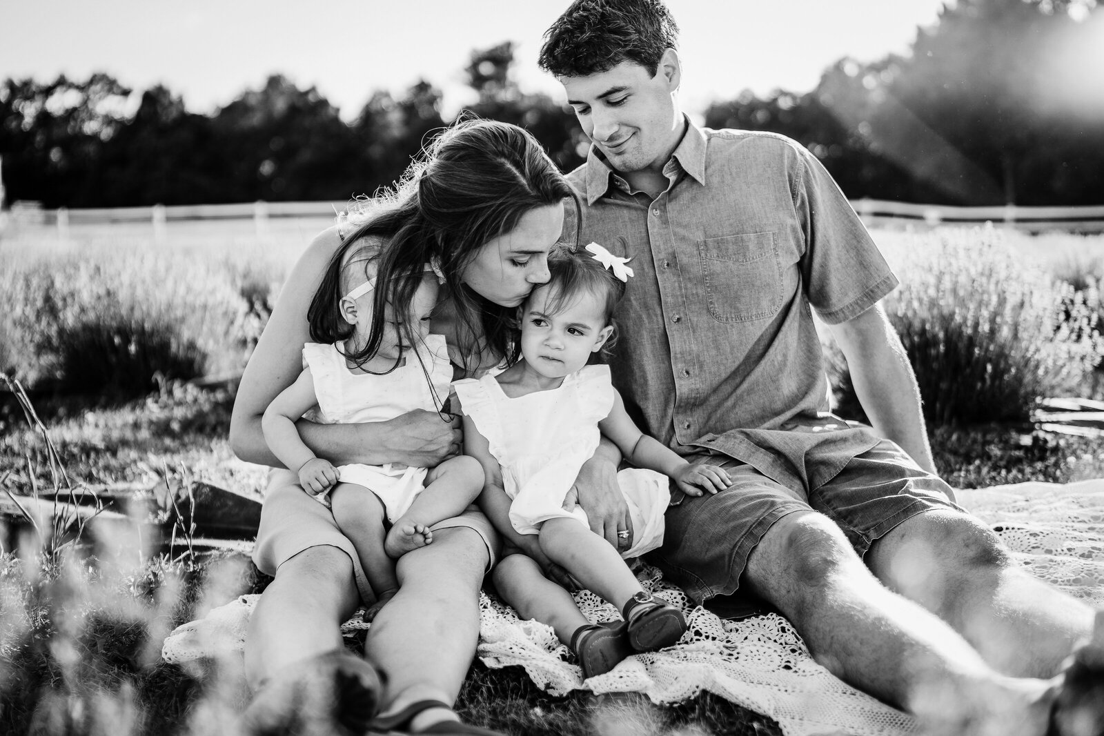 black and white image of a family of four snuggling