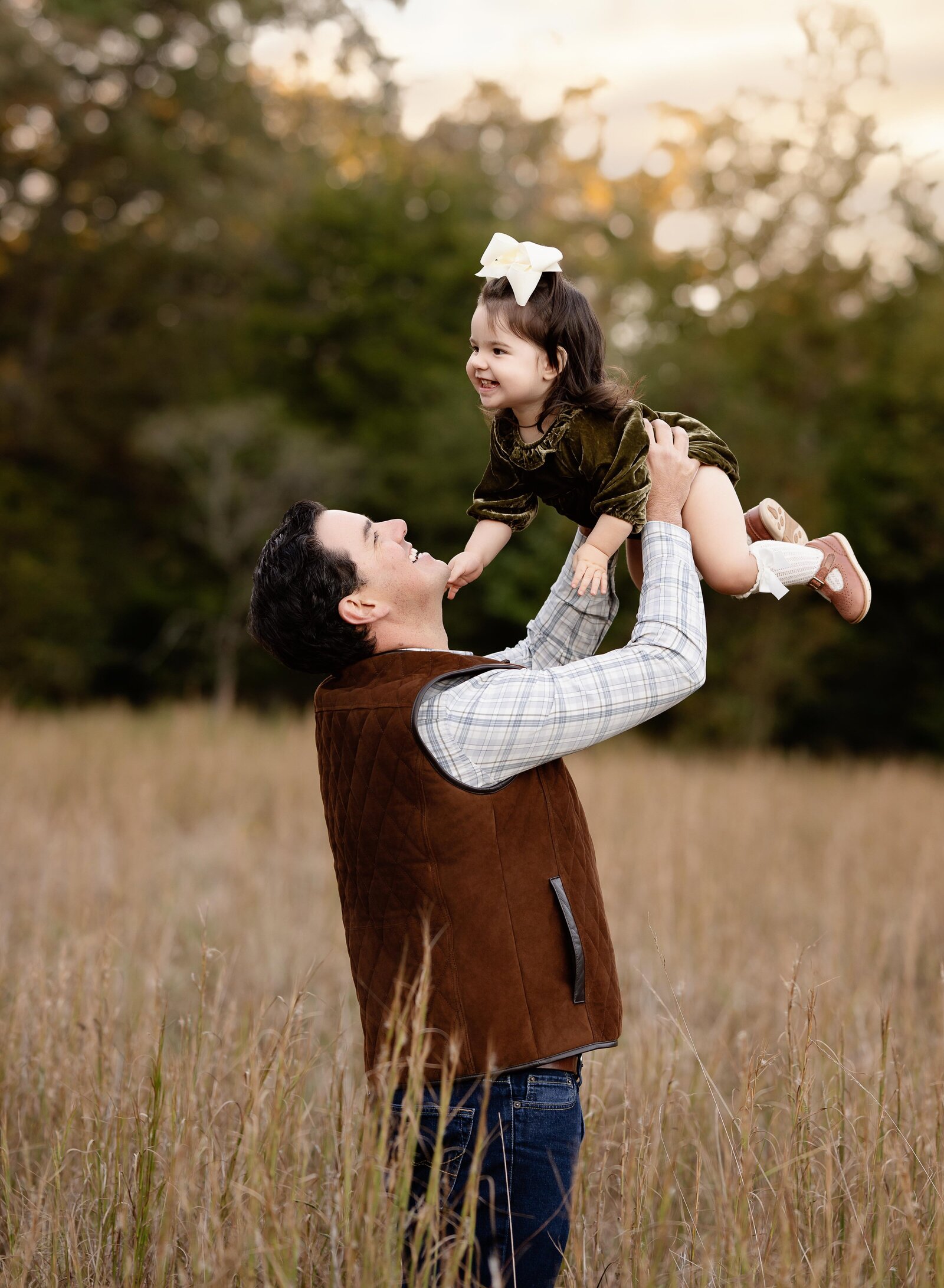 Dad tossing baby in air and laughing.