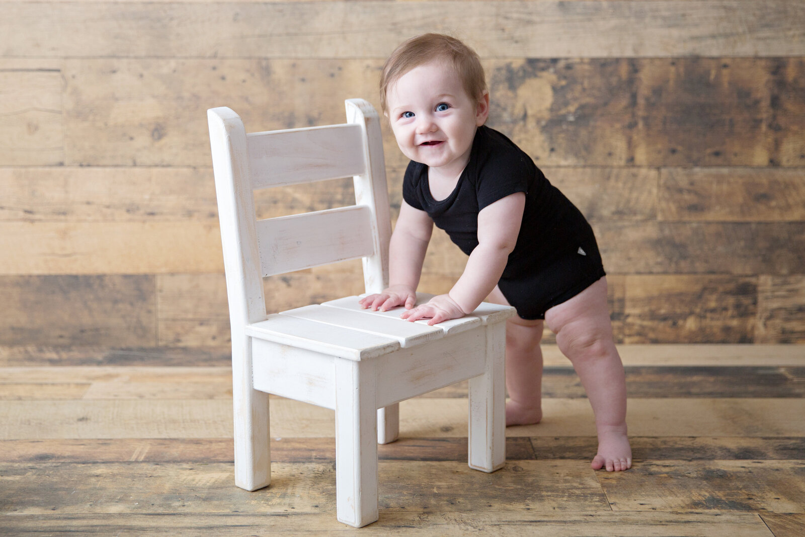 baby boy standing with chair