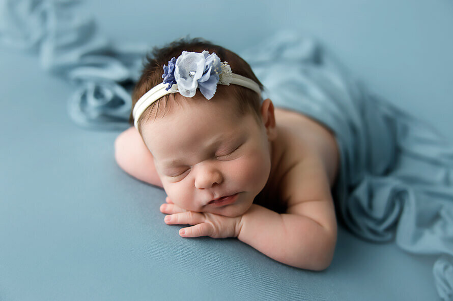 Newborn baby in a teal backdrop in Highlands Ranch, Colorado.