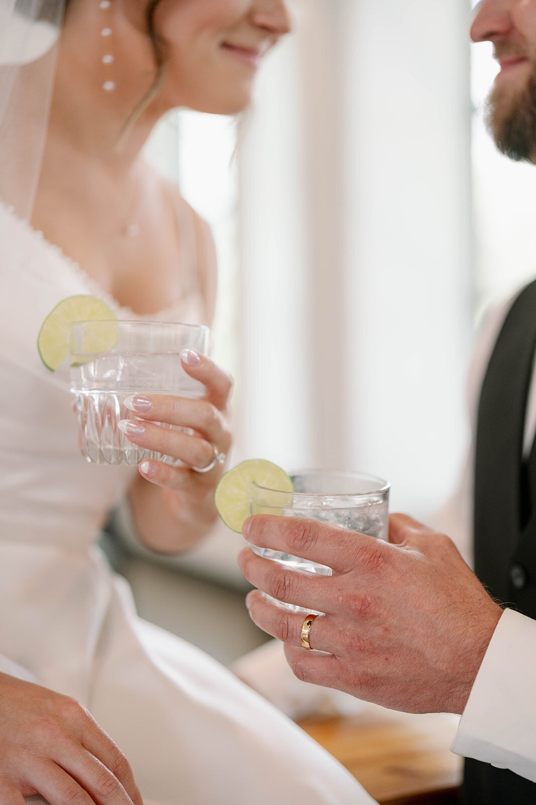 ride and groom clinking glasses with lime cocktails during their wedding celebration, photographed in editorial detail.