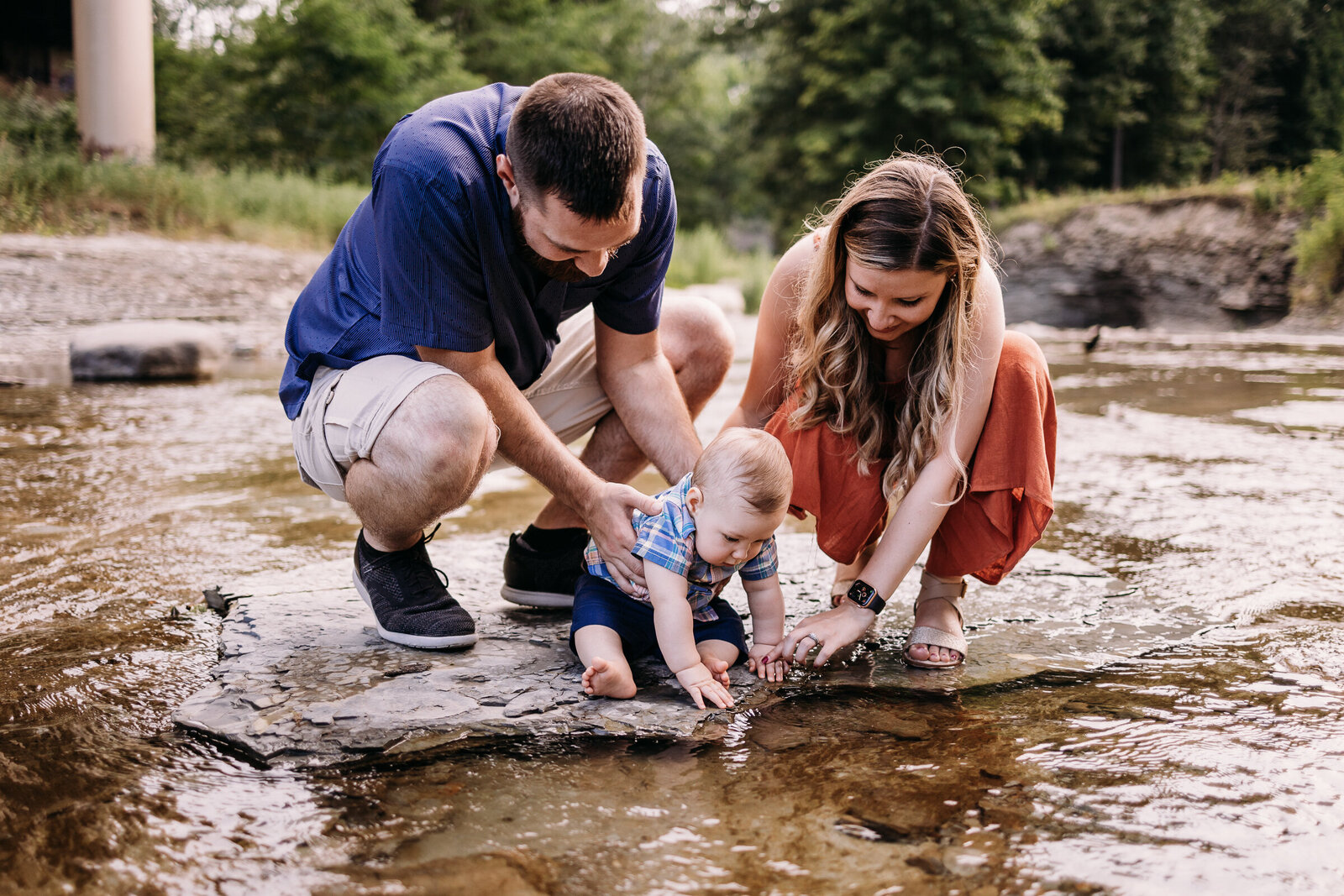 Mother and father playing in the creek with their toddler Erie, PA