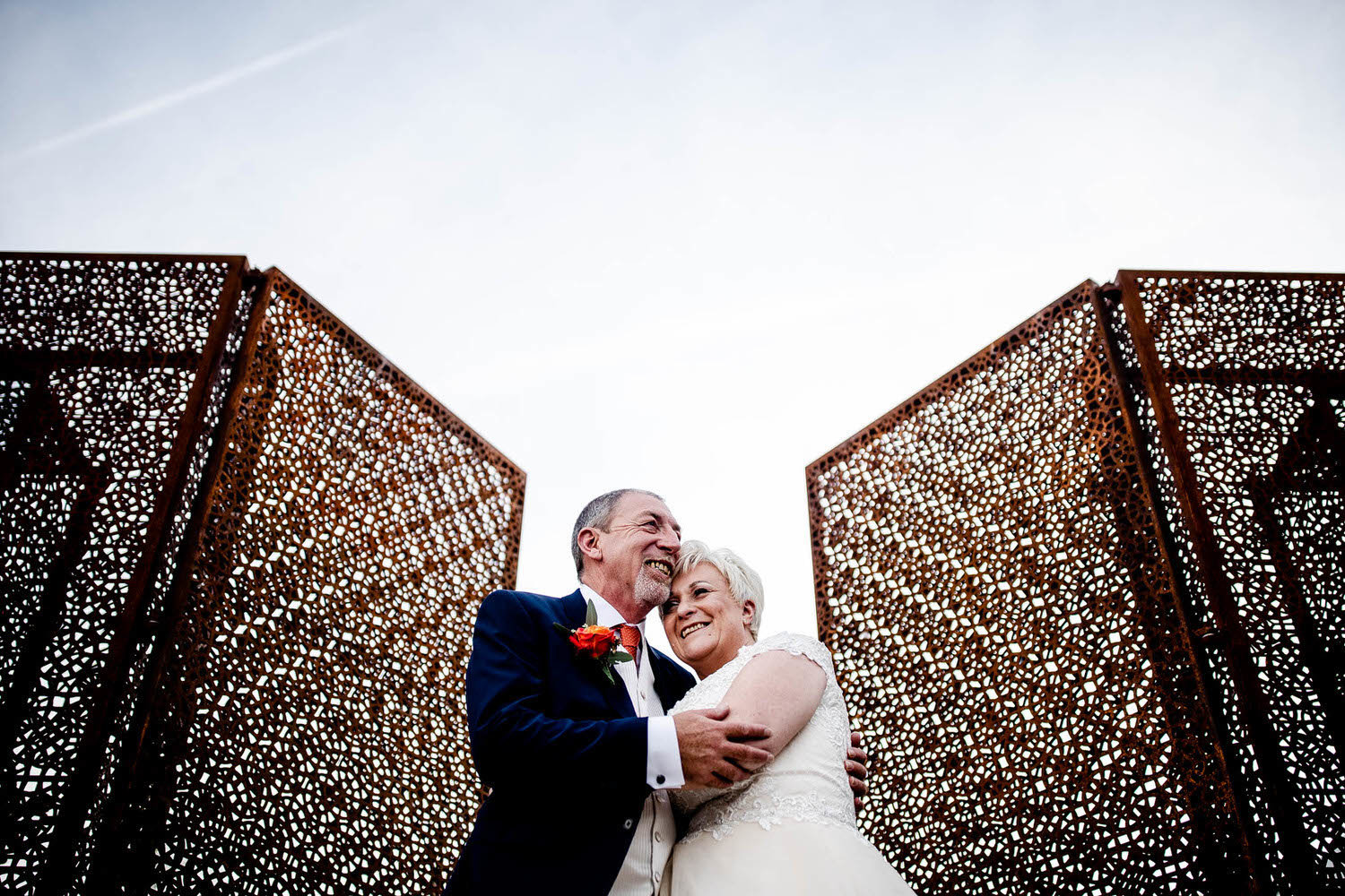 a bride and groom infront of a gate at the halston in carlisle