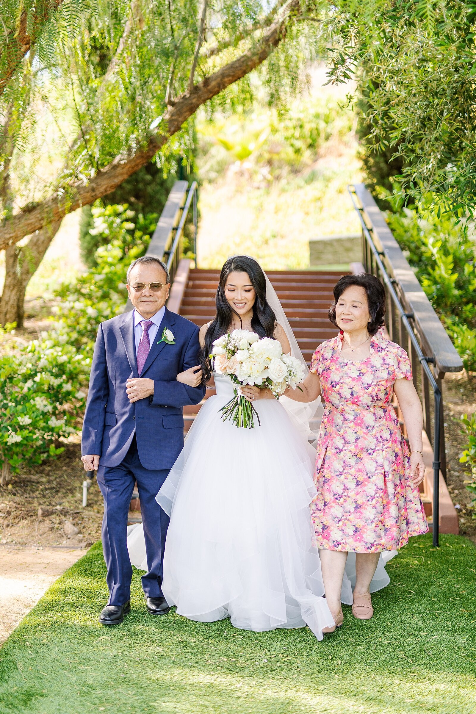 Bride walking with her parents down the aisle photographed by Sherr Weddings.