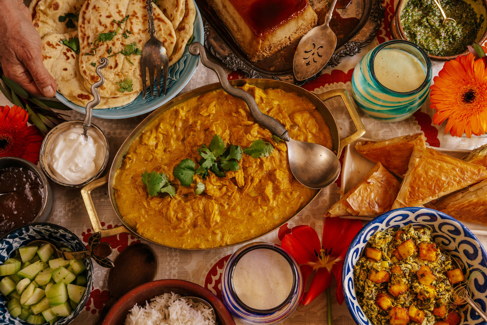 A table set with various bowls of Indian food, showcasing vibrant colors and traditional dishes ready to be enjoyed.