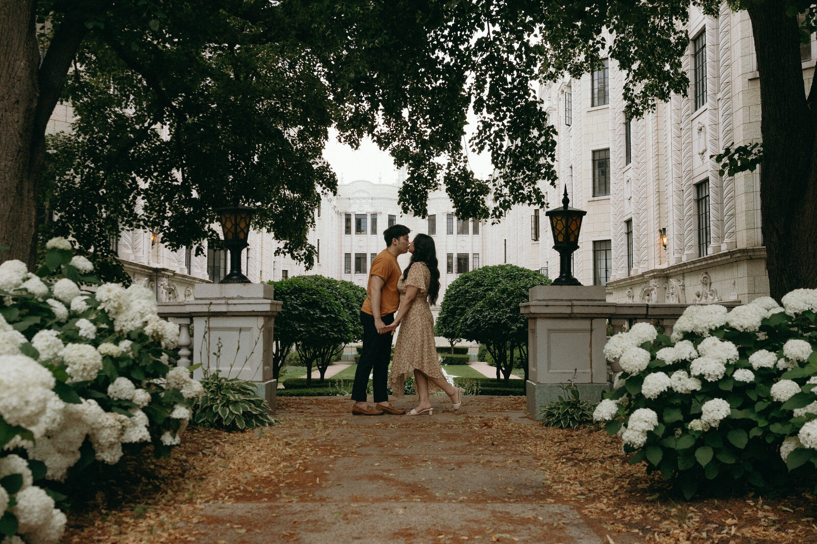 A wedding table set perfectly with orange napkins and the sun glaring onto the table making it glow