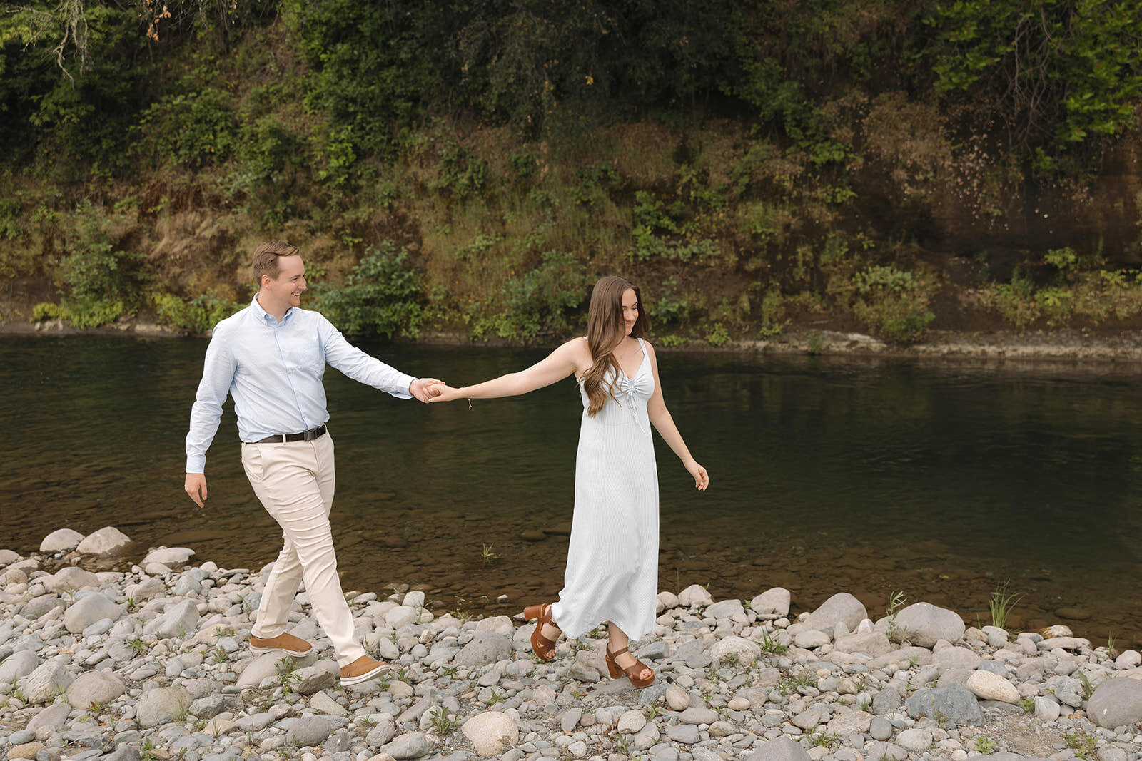 Engaged couple walking by the river