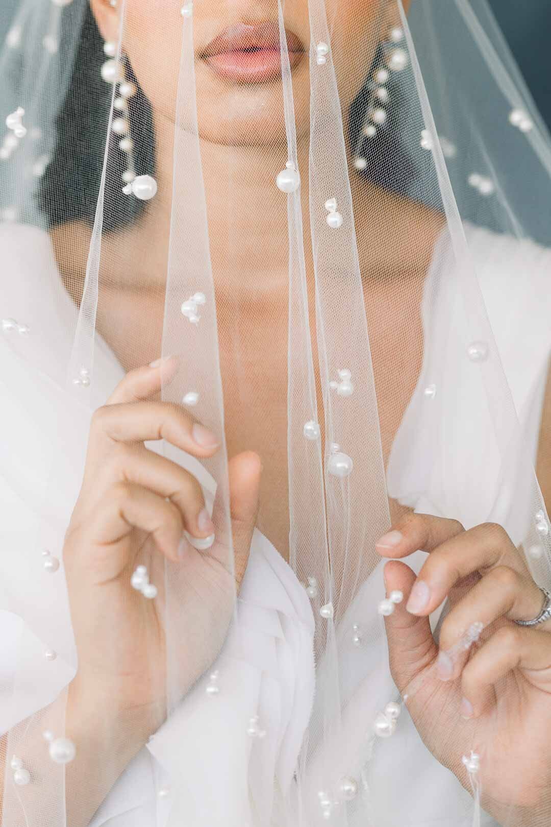 close up portirat Bride under wedding veil adorned with pearls