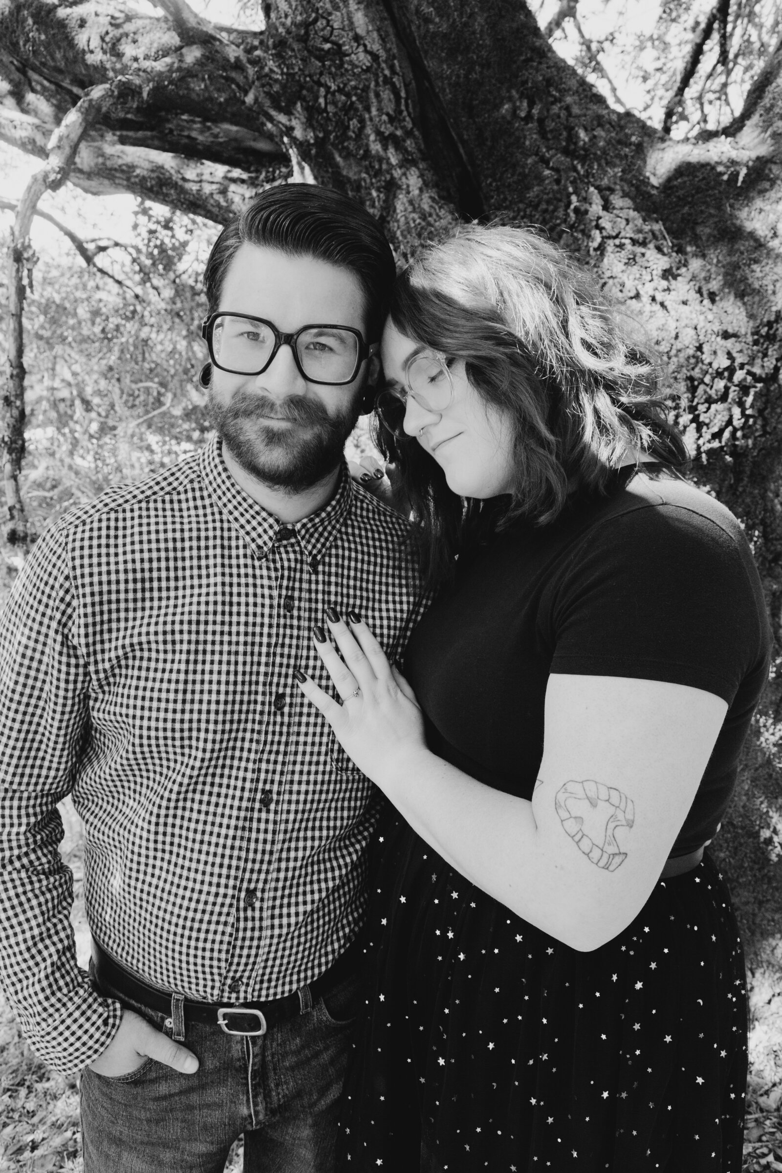 An tattooed engaged couple poses for photos in a redwood forest in Santa Cruz, Ca.