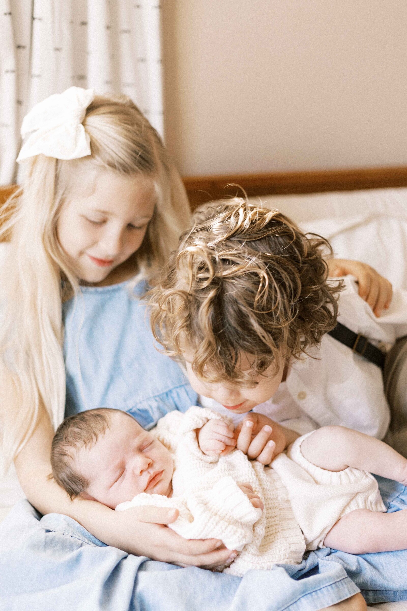 siblings looking at newborn baby in peoria illinois family photos 