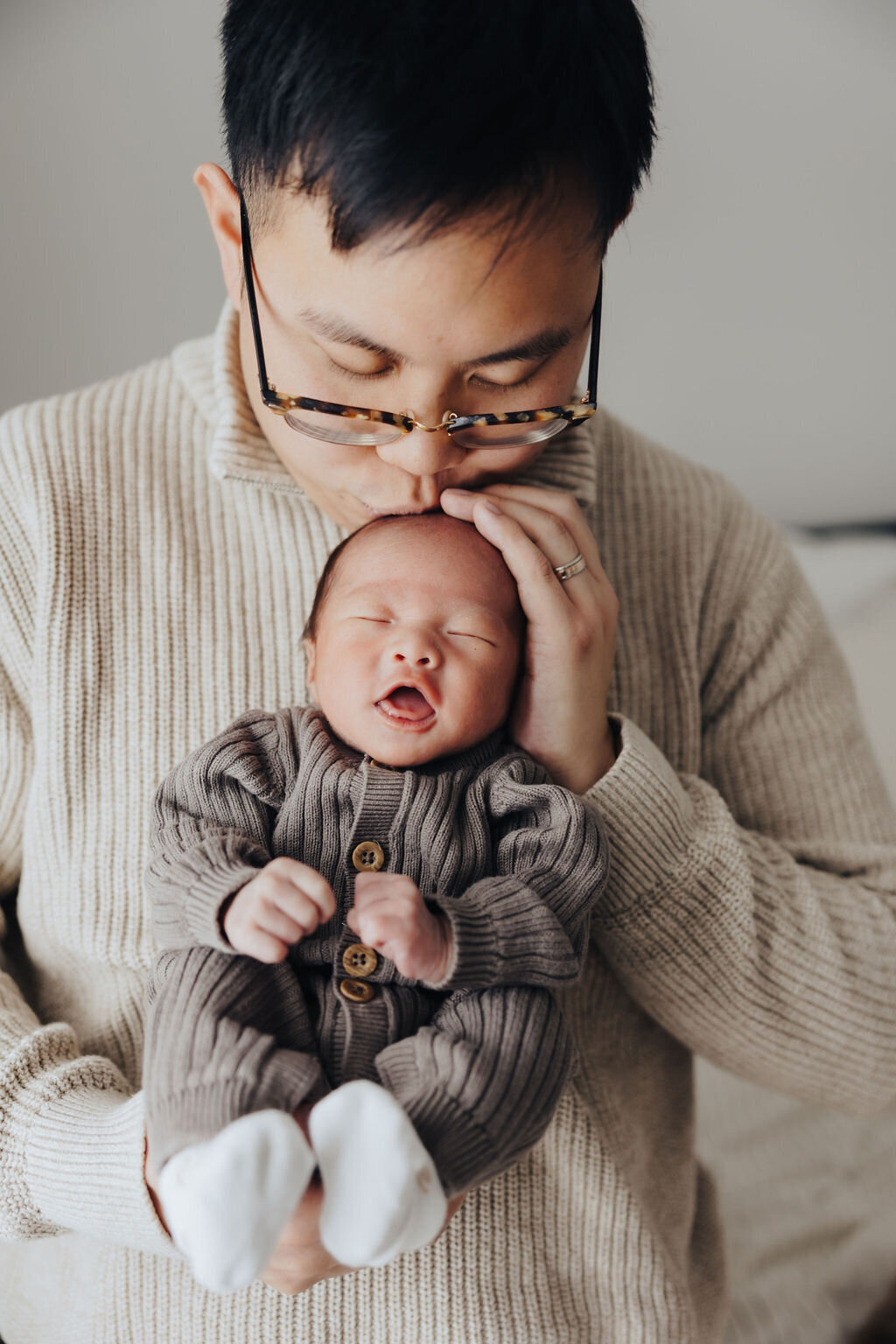 Dad kissing newborn baby