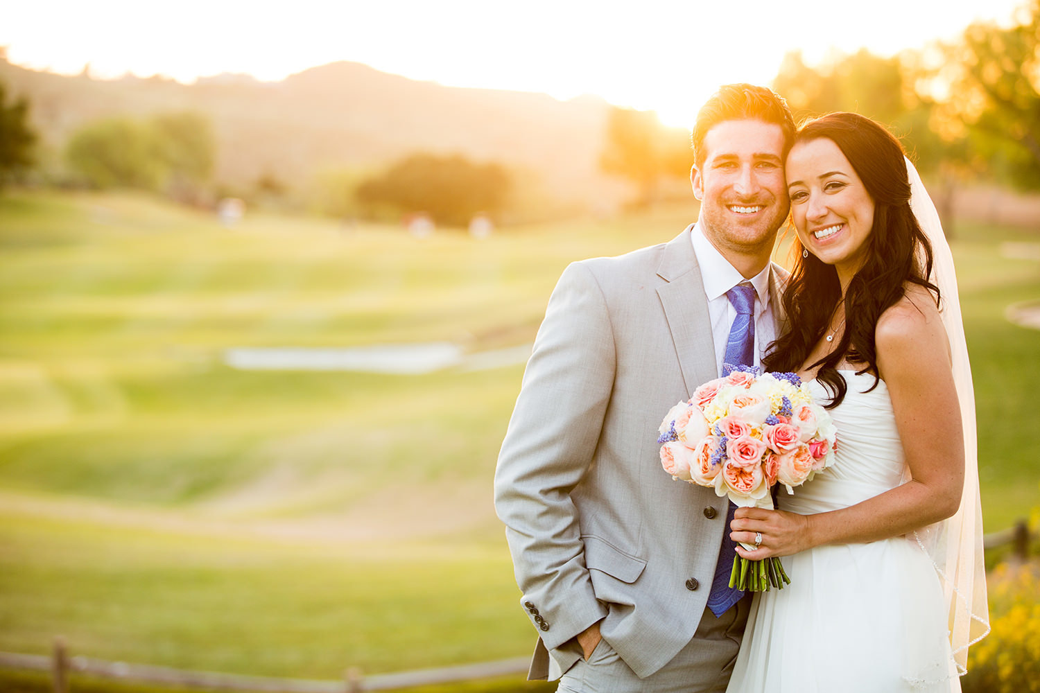 bride and groom with golf course in the background