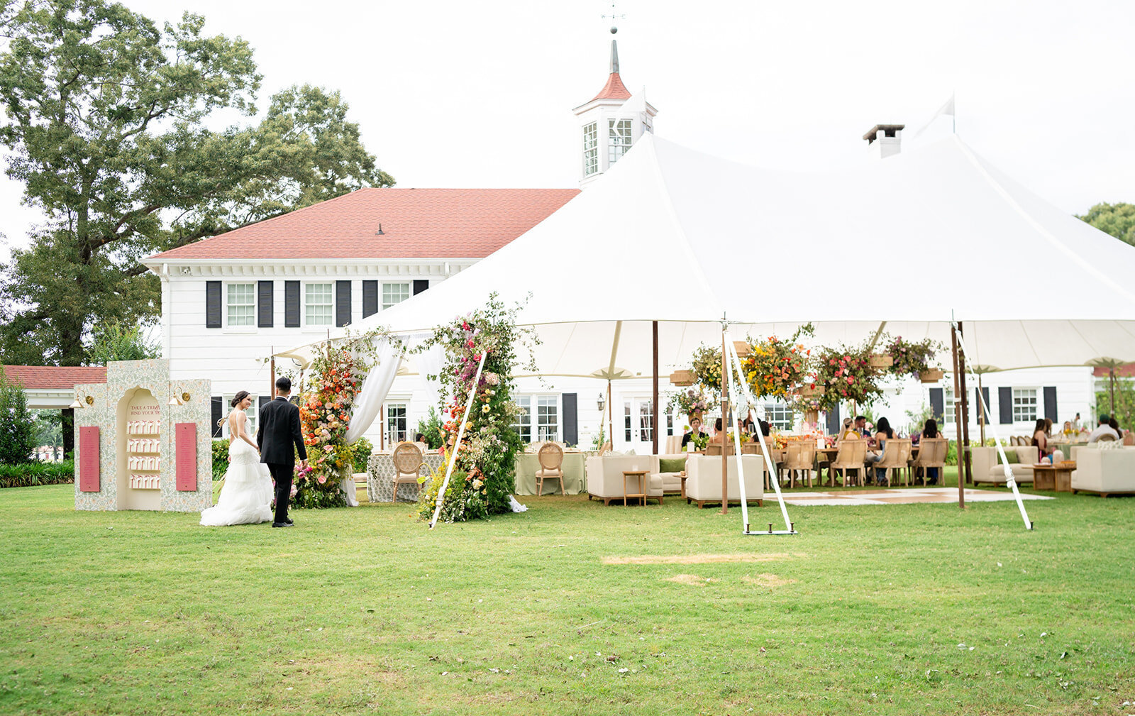 Bride and groom enter their luxurious tented wedding full of colorful florals and specialty rentals