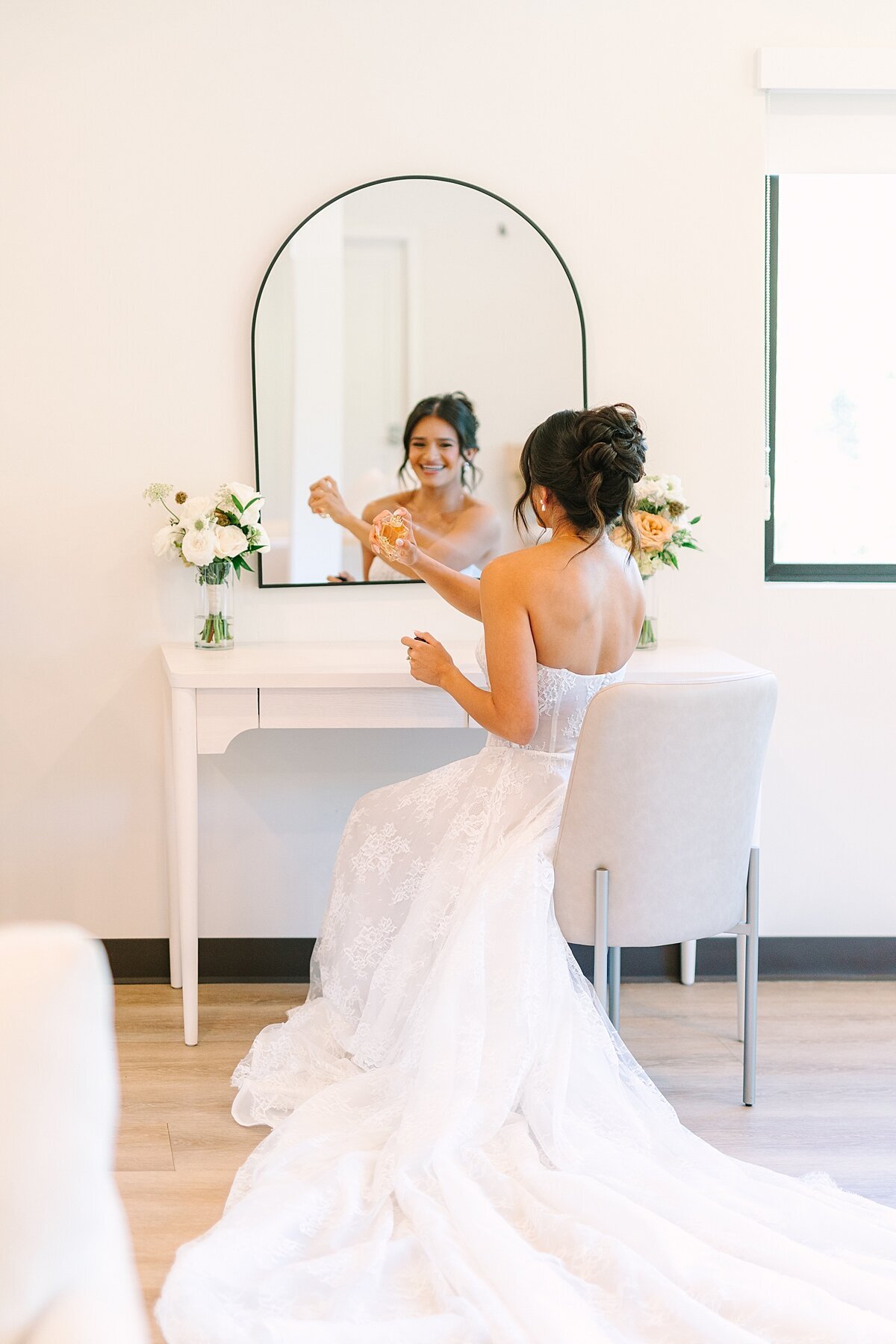 Bride spraying perfume on herself before her wedding ceremony in Escondido.