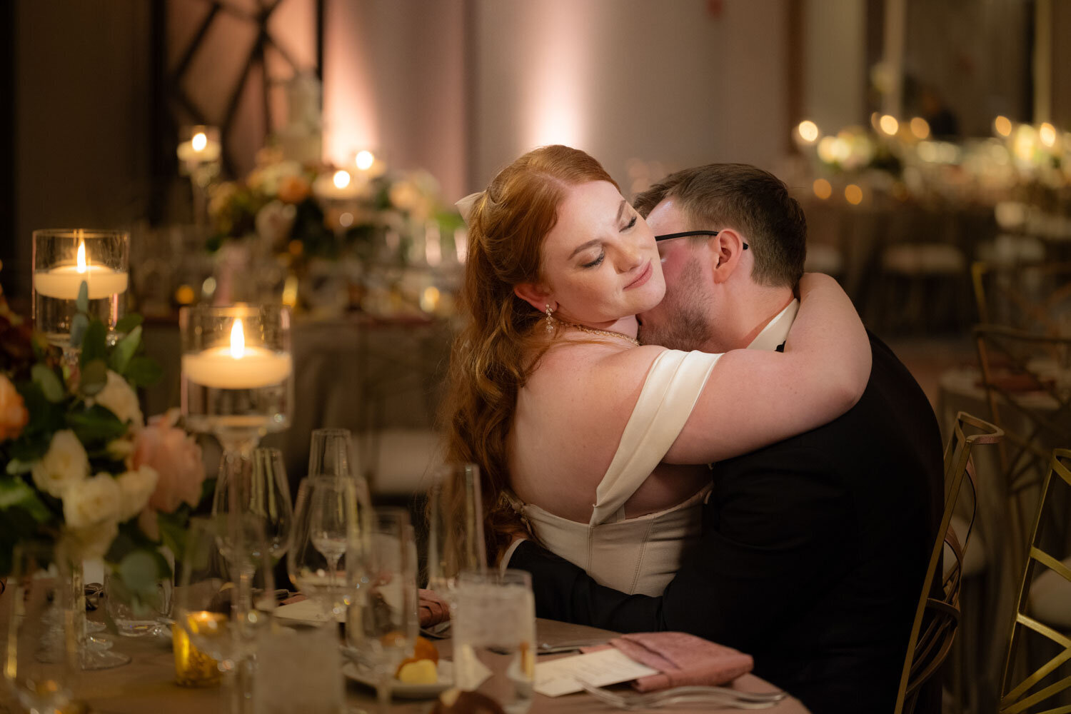 A man kissing a woman on the cheek at a wedding reception