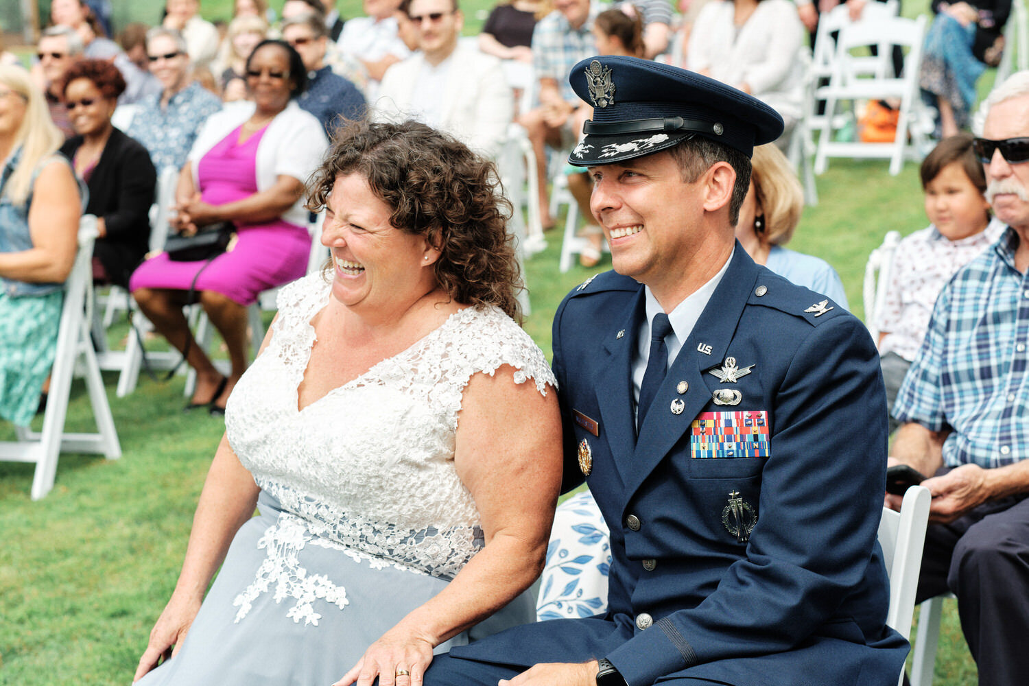 Mother and father of the bride in military dress watch the wedding ceremony.