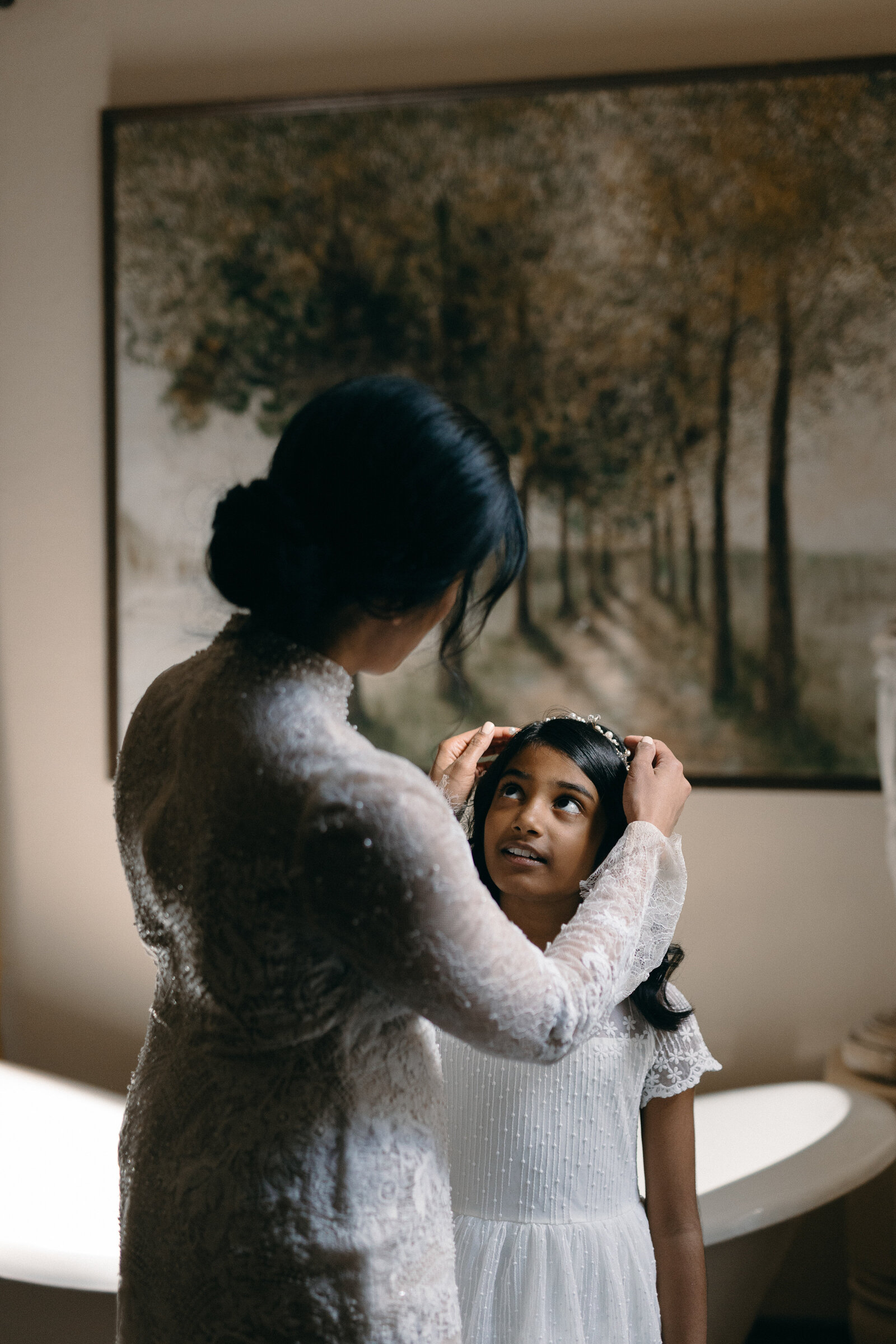 Bride putting a tiara on a flower girl.