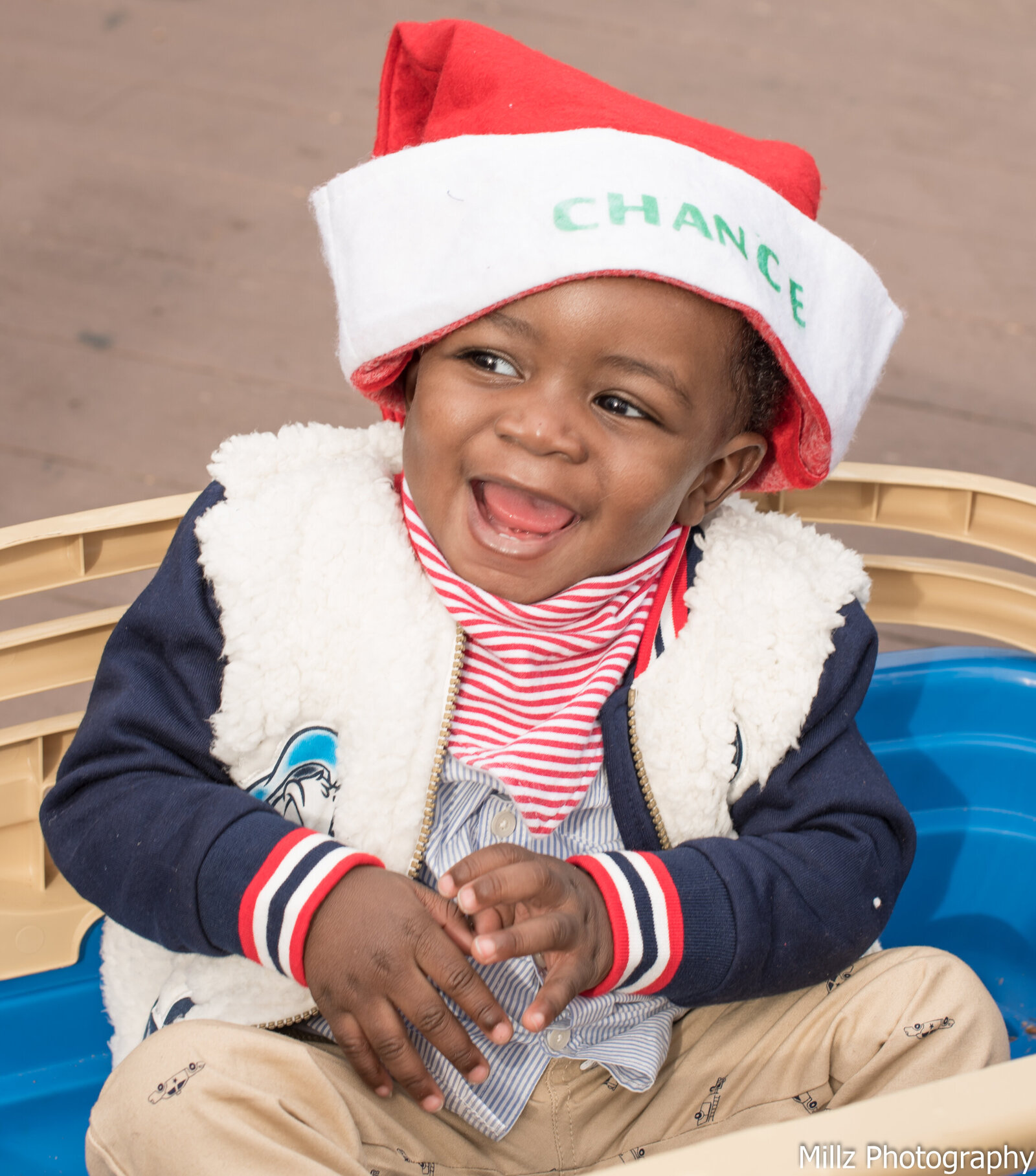 young boy wearing a santa hat that says Chance laughing photographed by Millz Photography in Greenville, SC