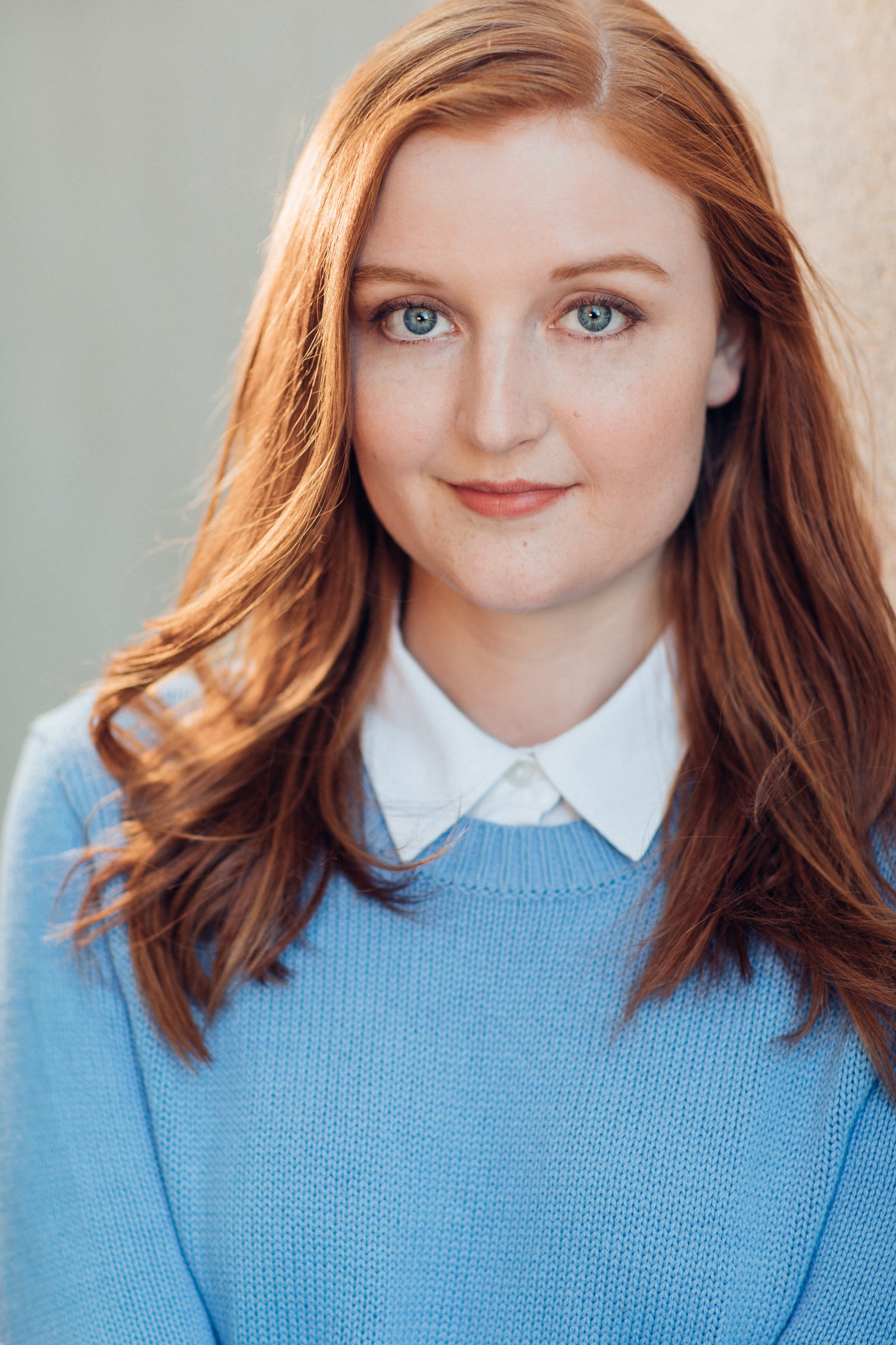 Headshot Photo Of Young Woman In Sky Blue Sweater