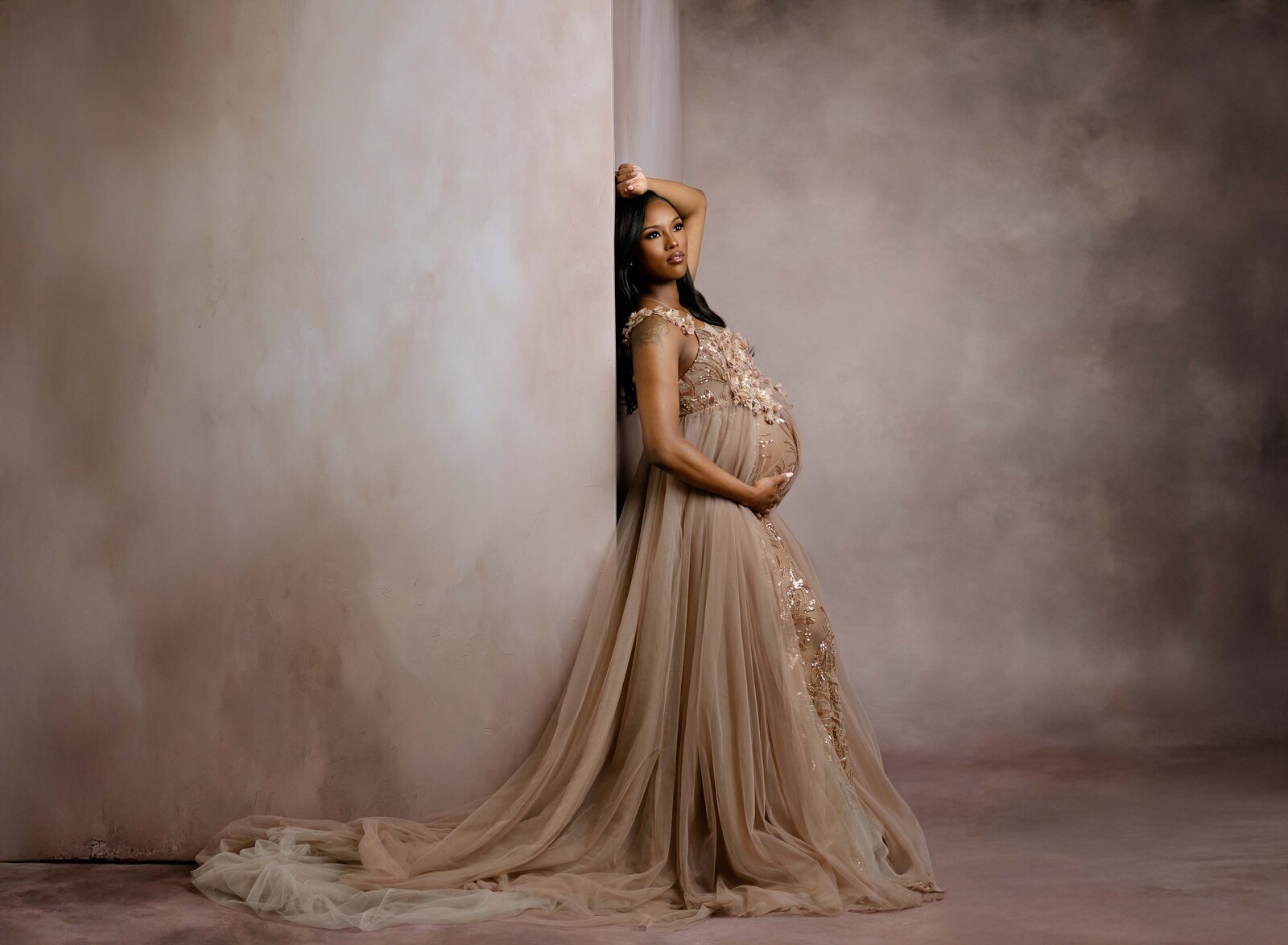 Pregnant women leaning on wall holding baby bump. Photographed by Atlanta Maternity photographer.