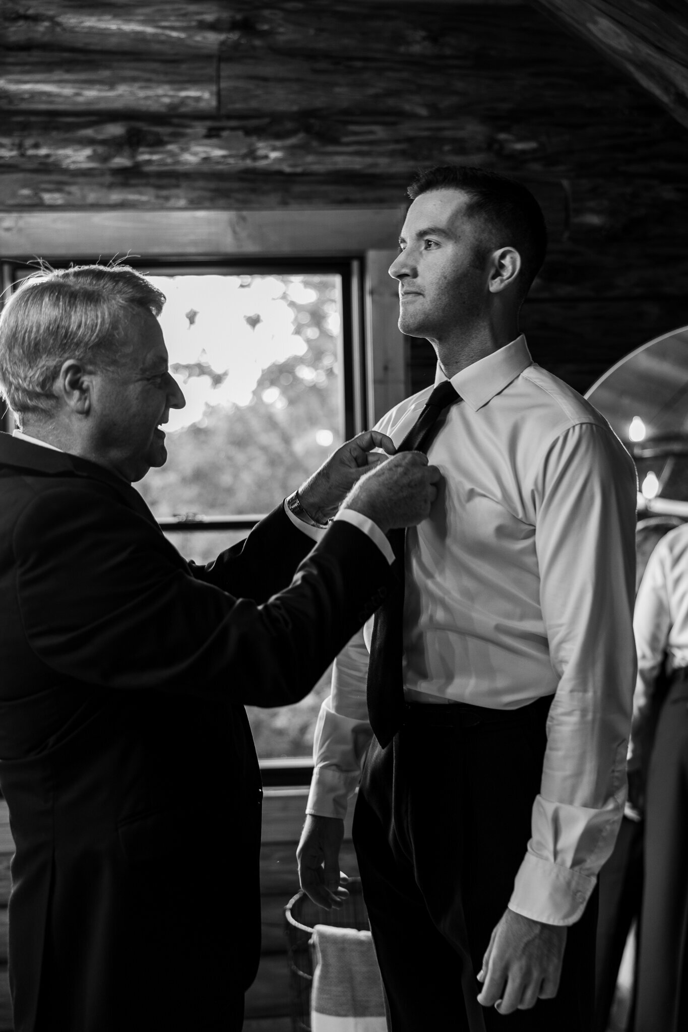 Groom’s father helping him fix his tie in a touching moment at SkyView Golf Club