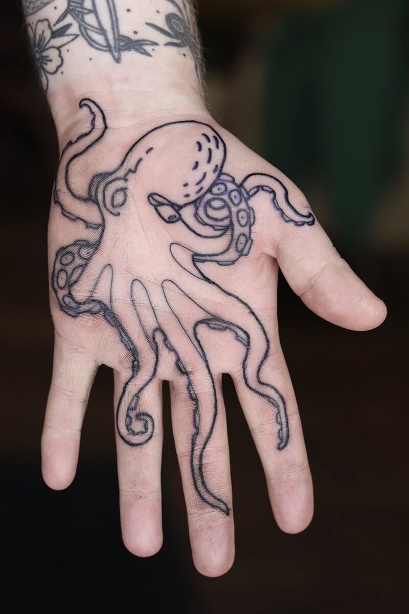 Tatuering i handflata av bläckfisk.