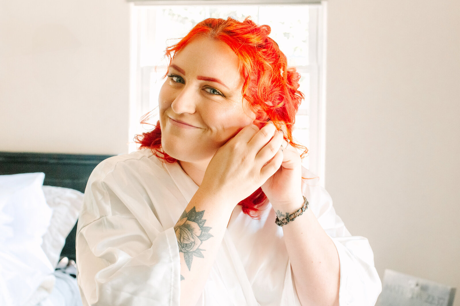 A bride with red hair and tattoos gets ready on her wedding day.