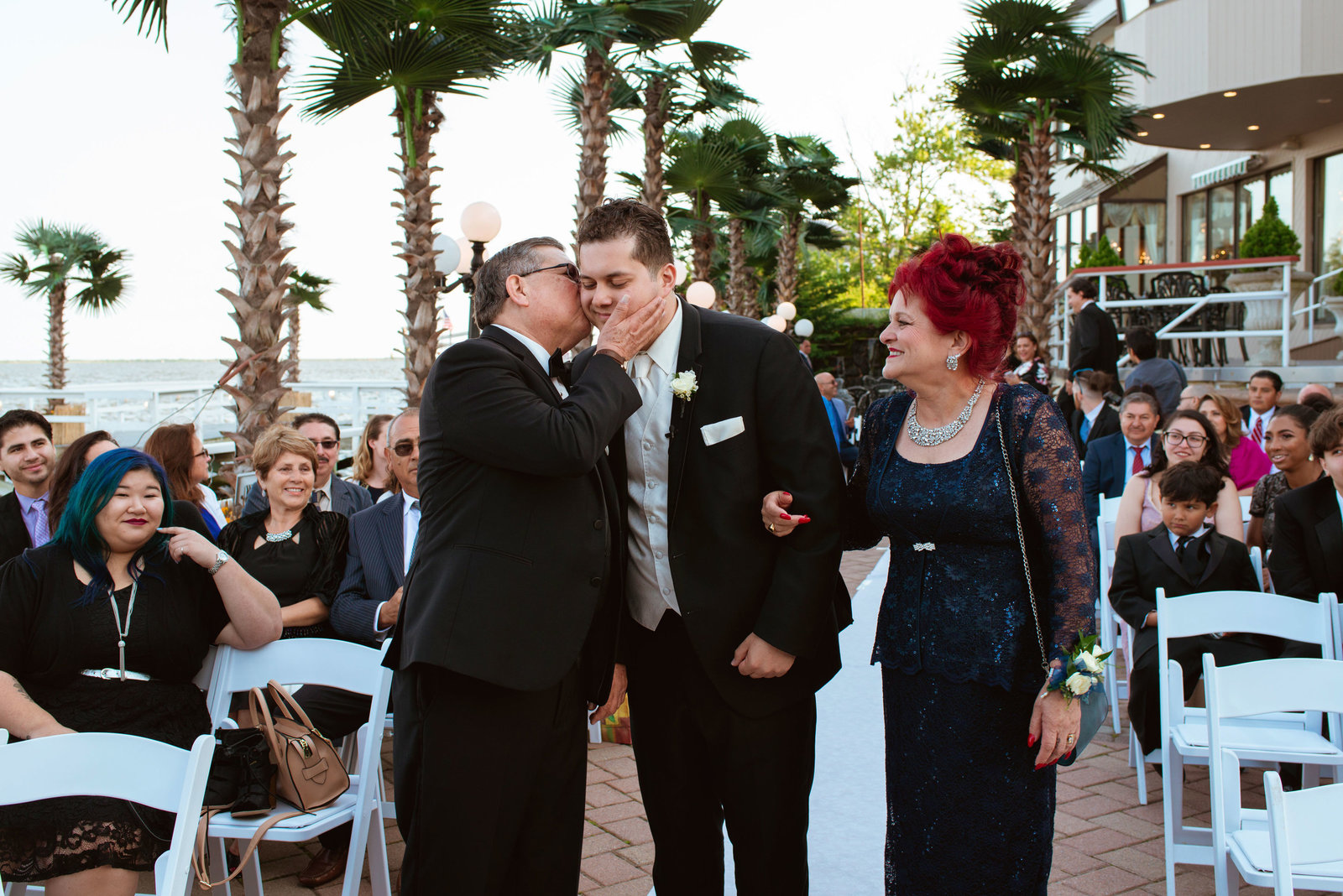 Groom and parents walking down the aisle at Chateau La Mer