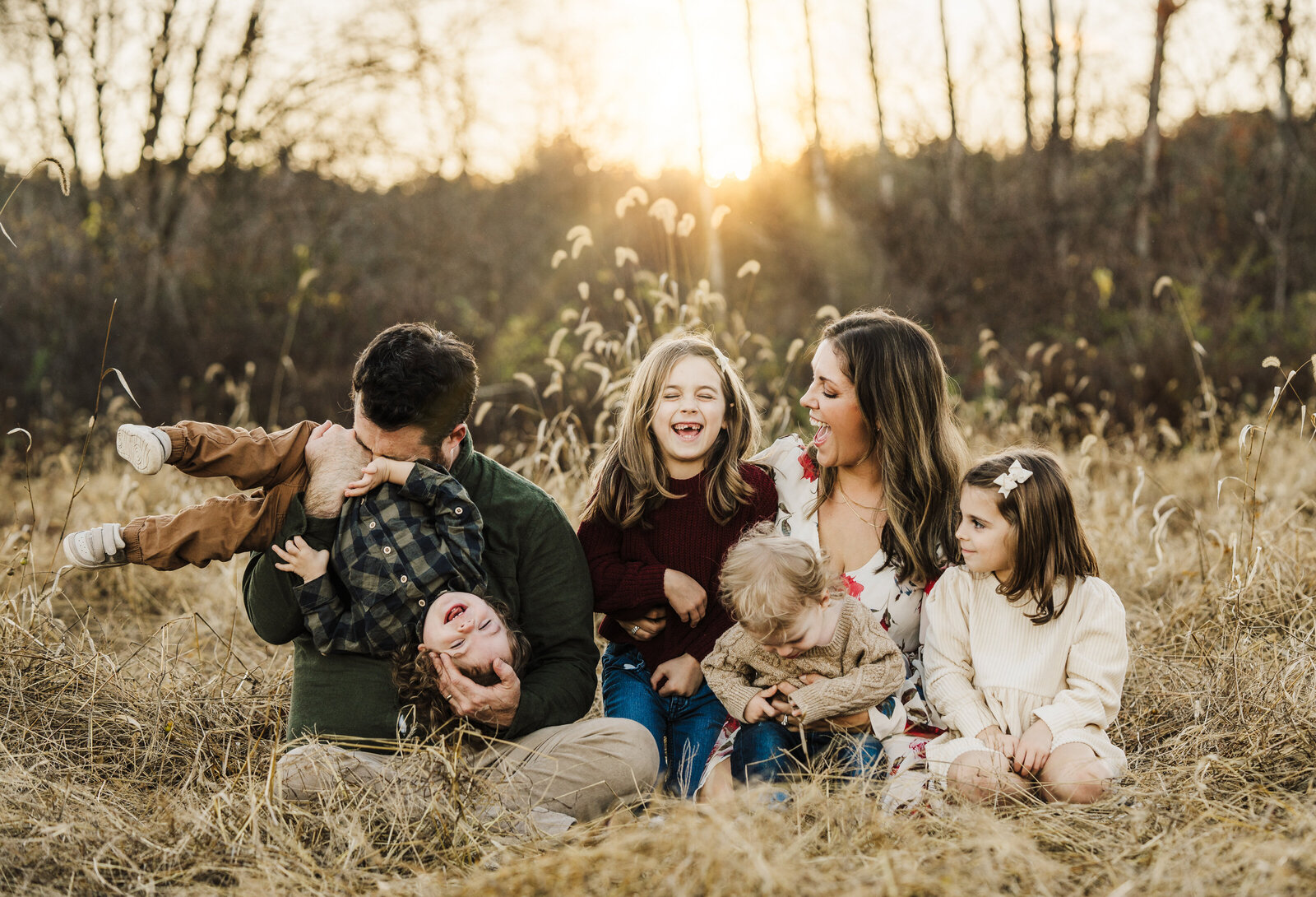 family of six in a field at sunset