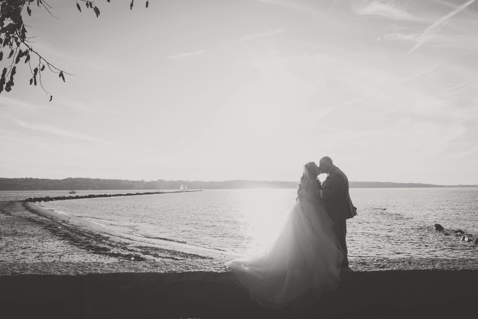 black and white photo of bride and groom kissing by the water at Sea Cliff Manor