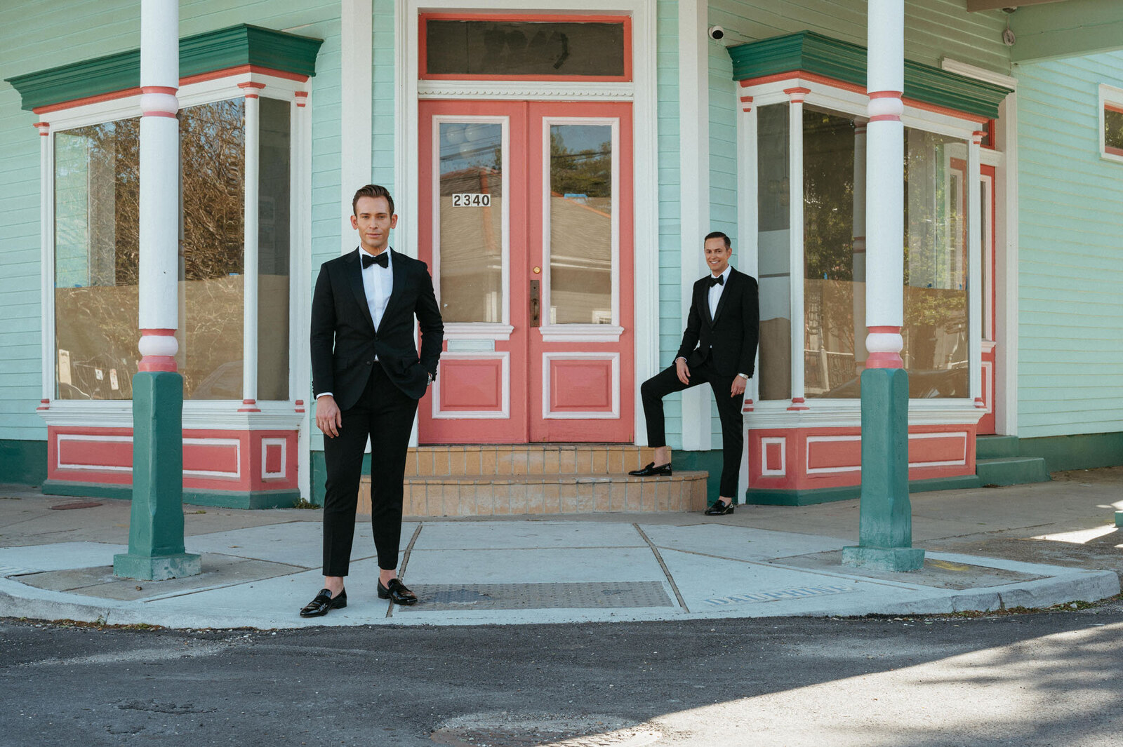 groom and groom sitting outside of New Orleans shop