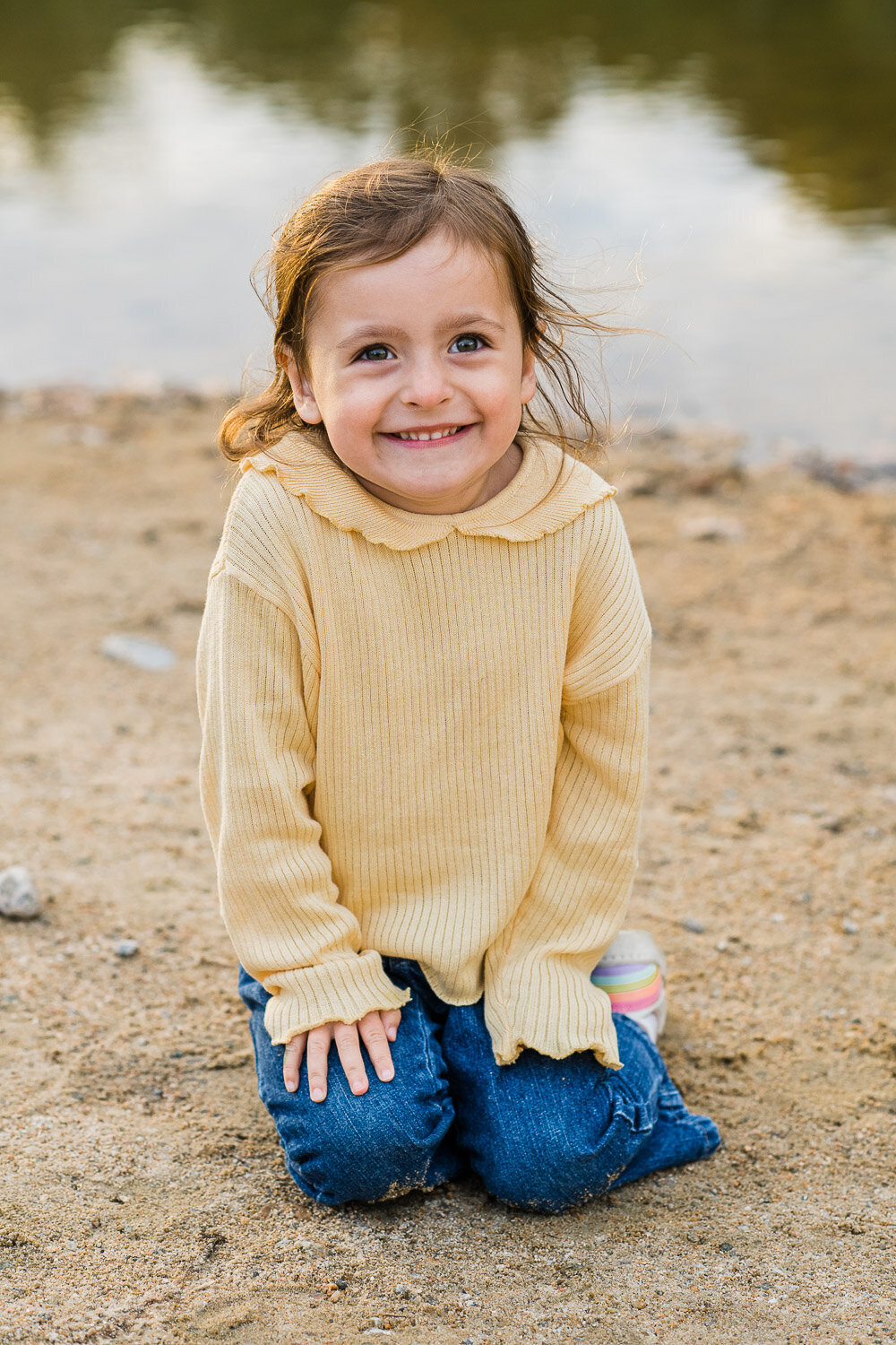 toddler girl sitting in sand