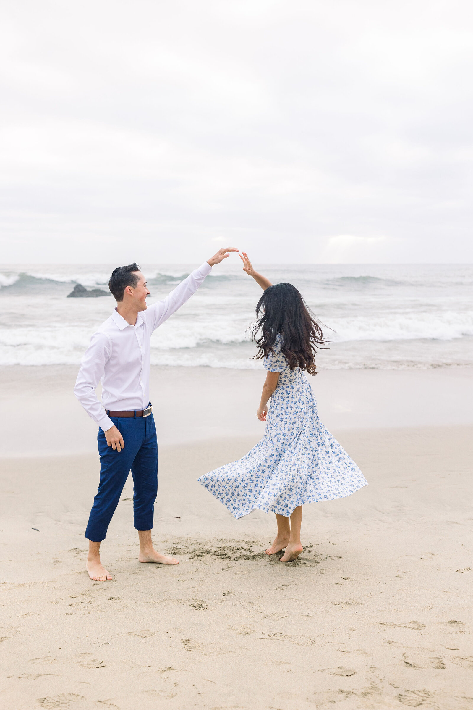 wedding photographer bay area captures man and woman dancing on the beach at Half Moon Bay for beach engagement pictures