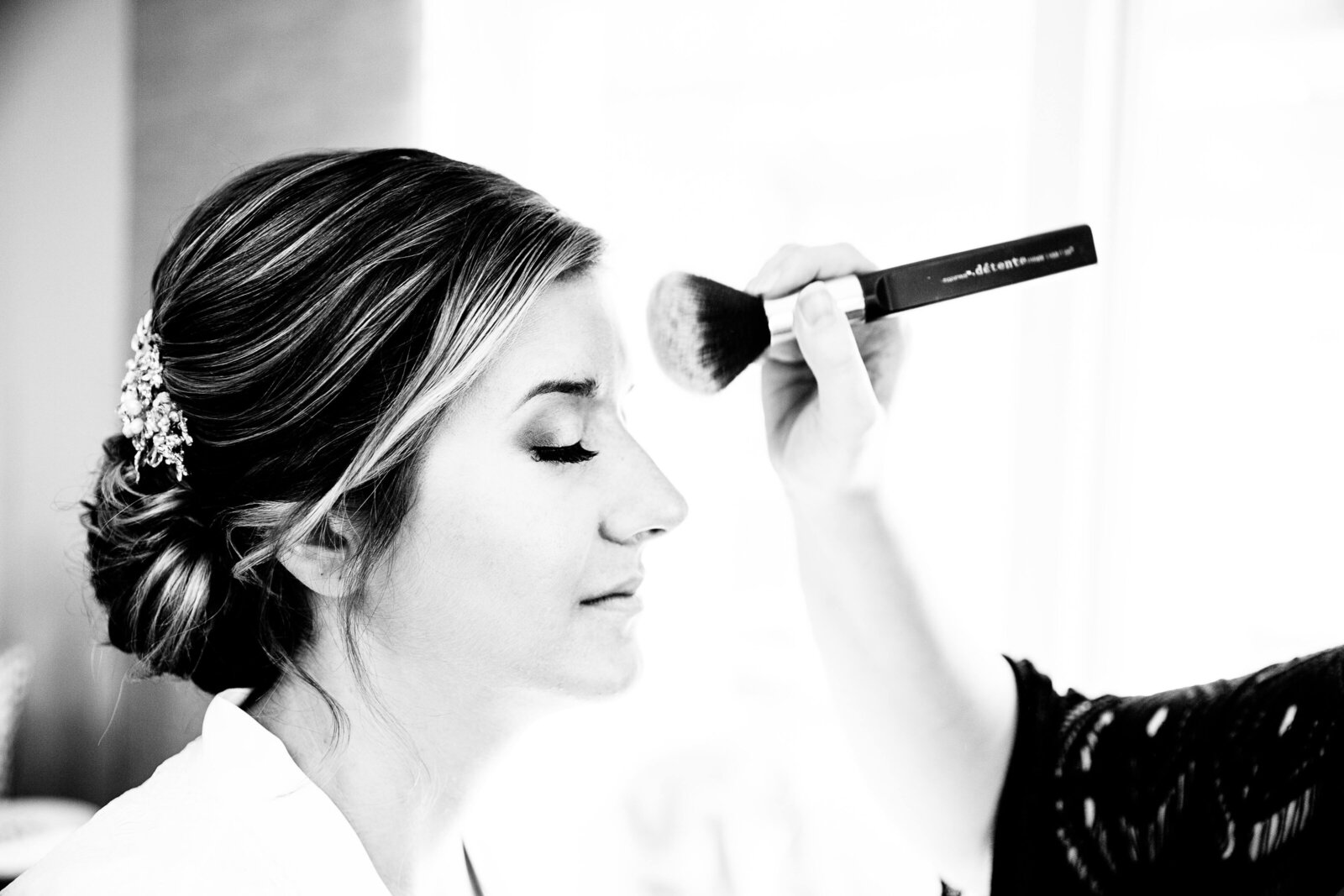 Bridal makeup being applied during getting ready portion of wedding day.