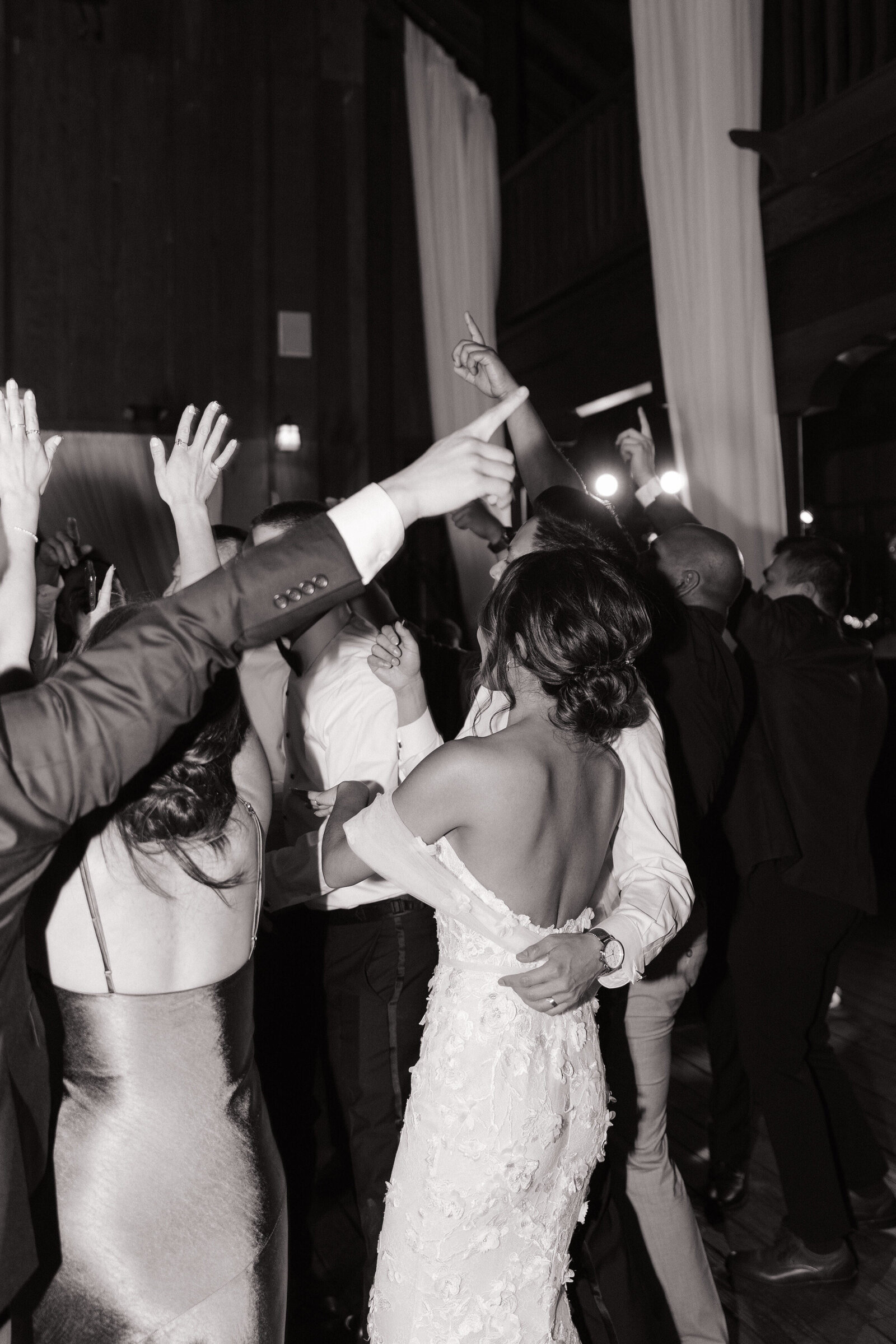 Wedding guests dance wildly around bride and groom during Seattle reception dance floor photos