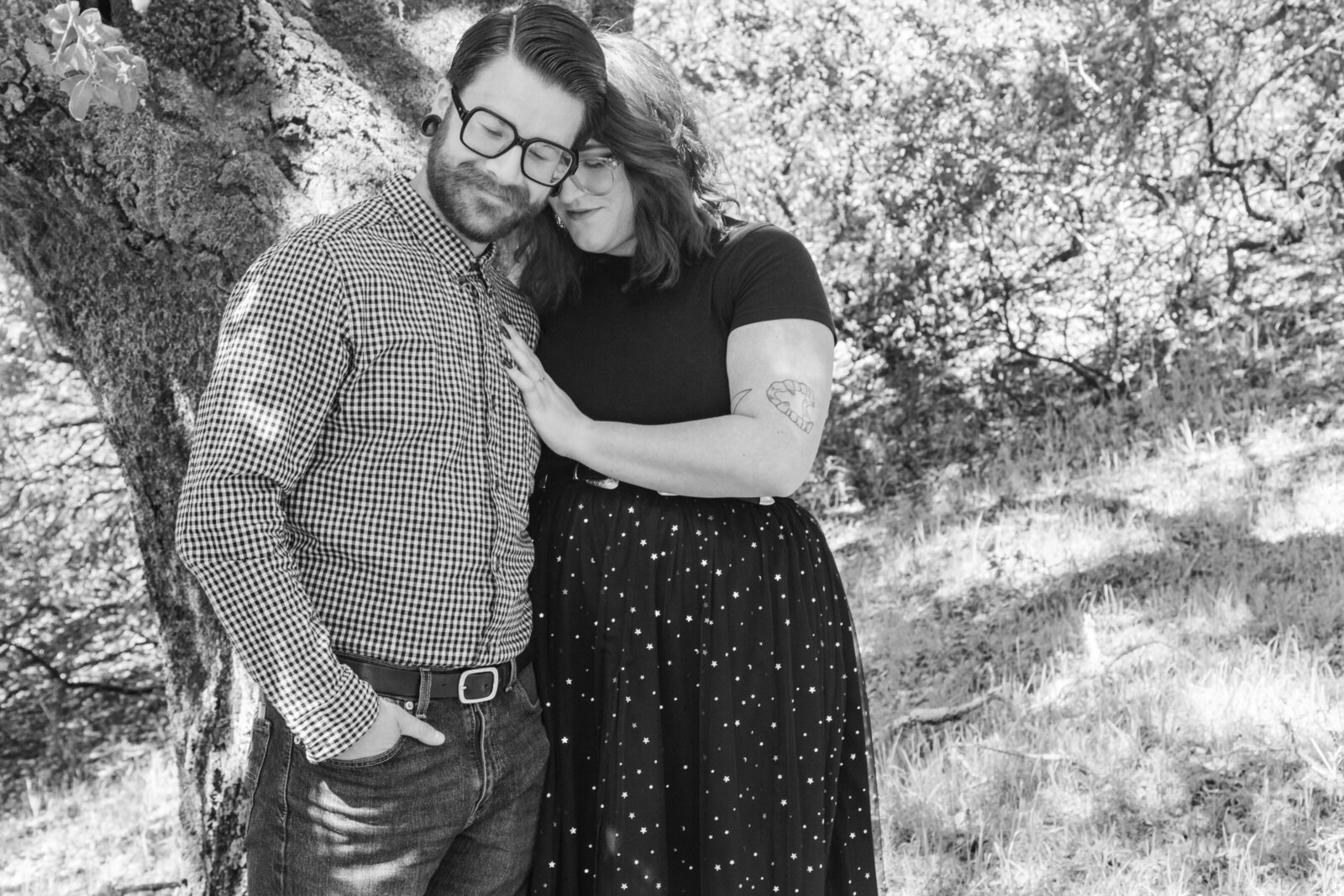 An tattooed engaged couple poses for photos in a redwood forest in Santa Cruz, Ca.