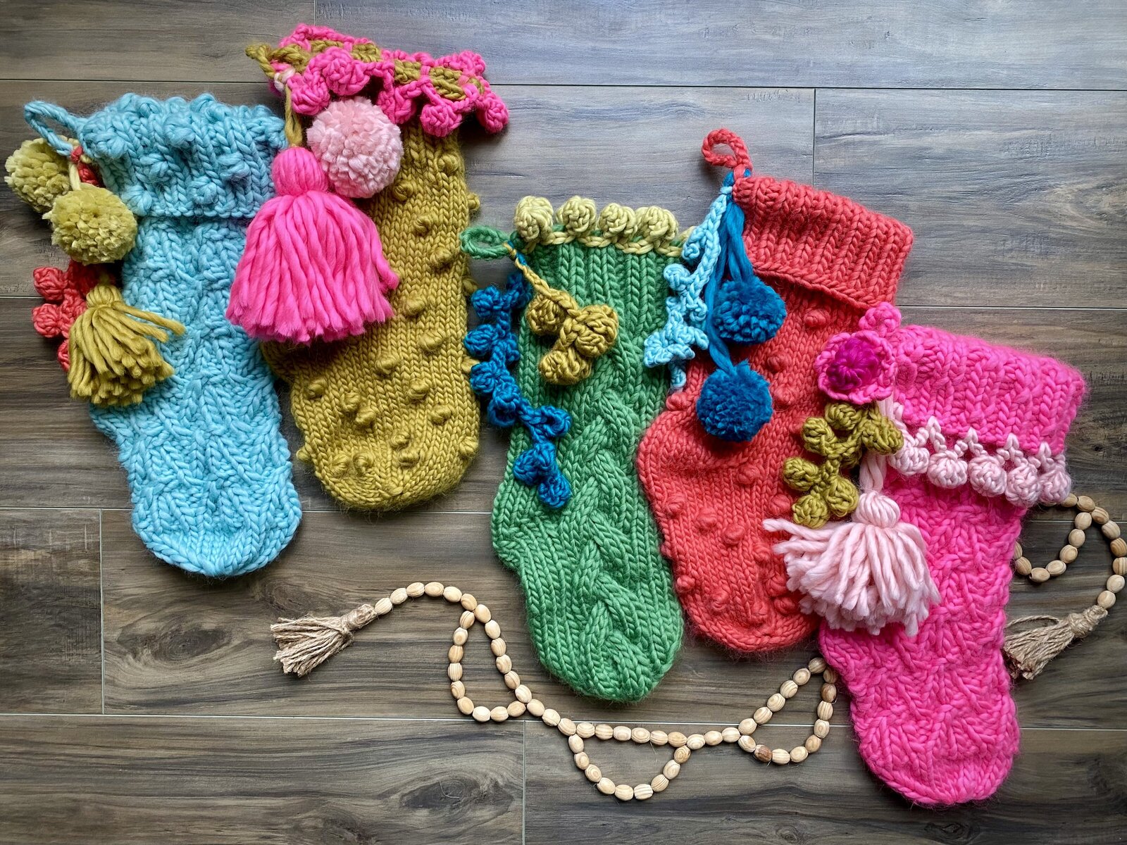 Colorful hand knit stockings with pom poms and tassels