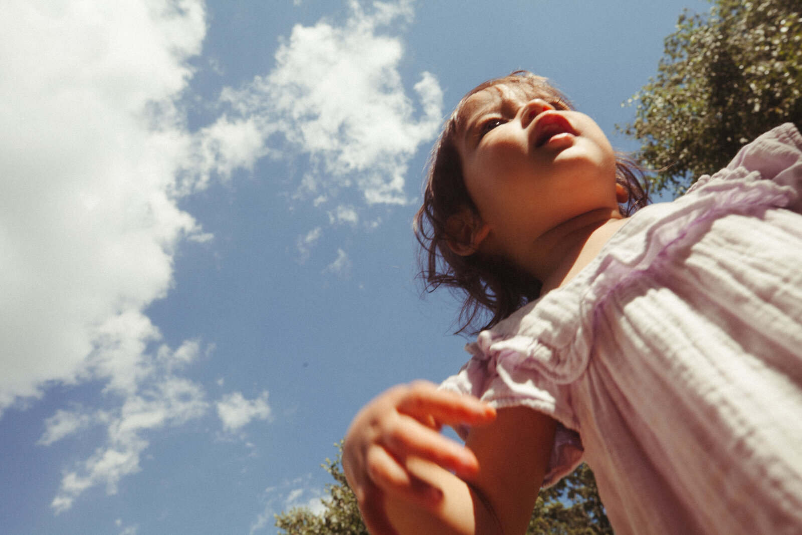 Candid documentary style photo of little girl smiling at camera.