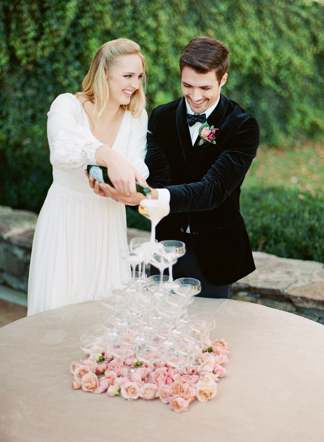 Bride and Groom pouring champagne into tower of glasses at Bettys Creek