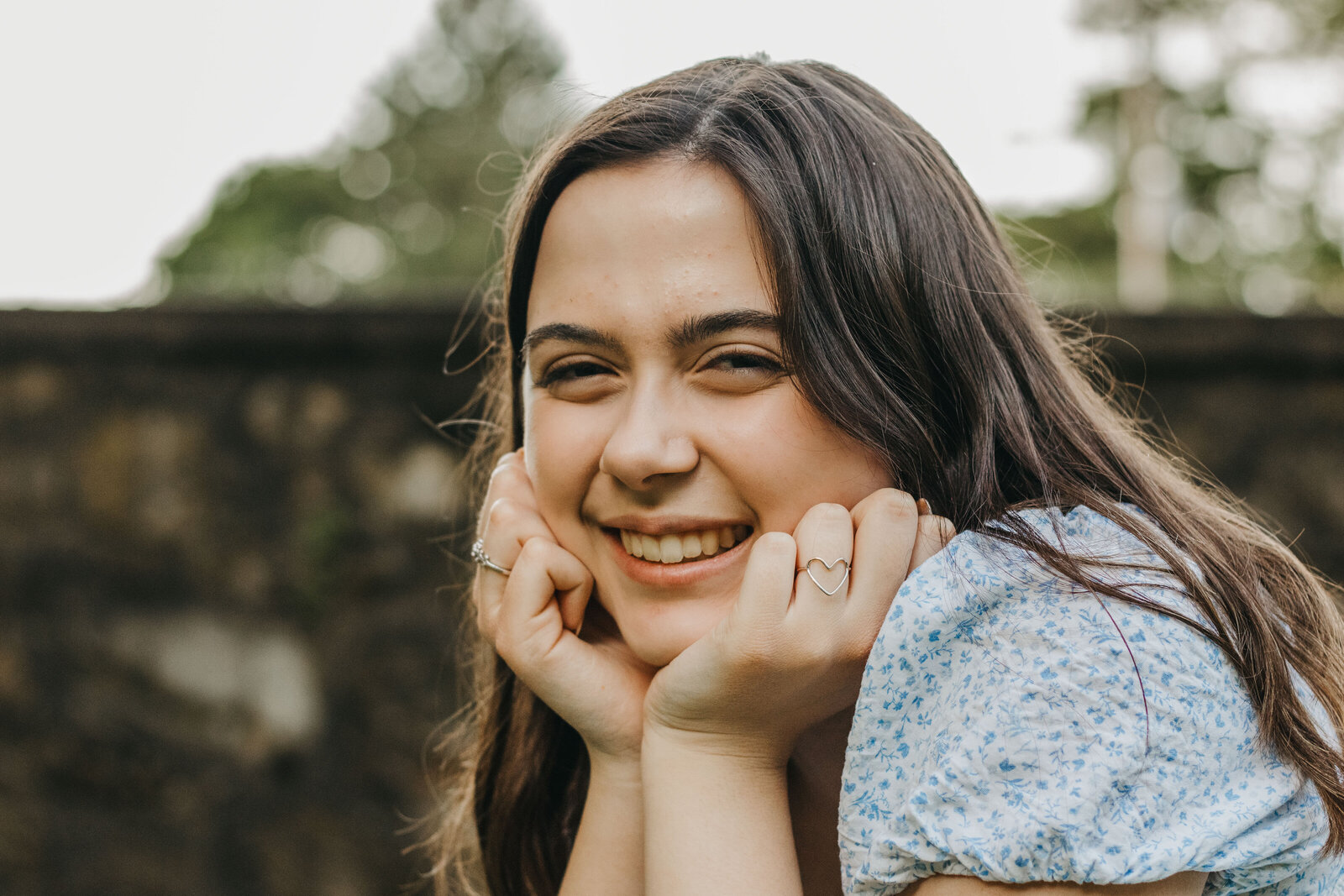 senior girl rests chin in her hands during senior portrait session