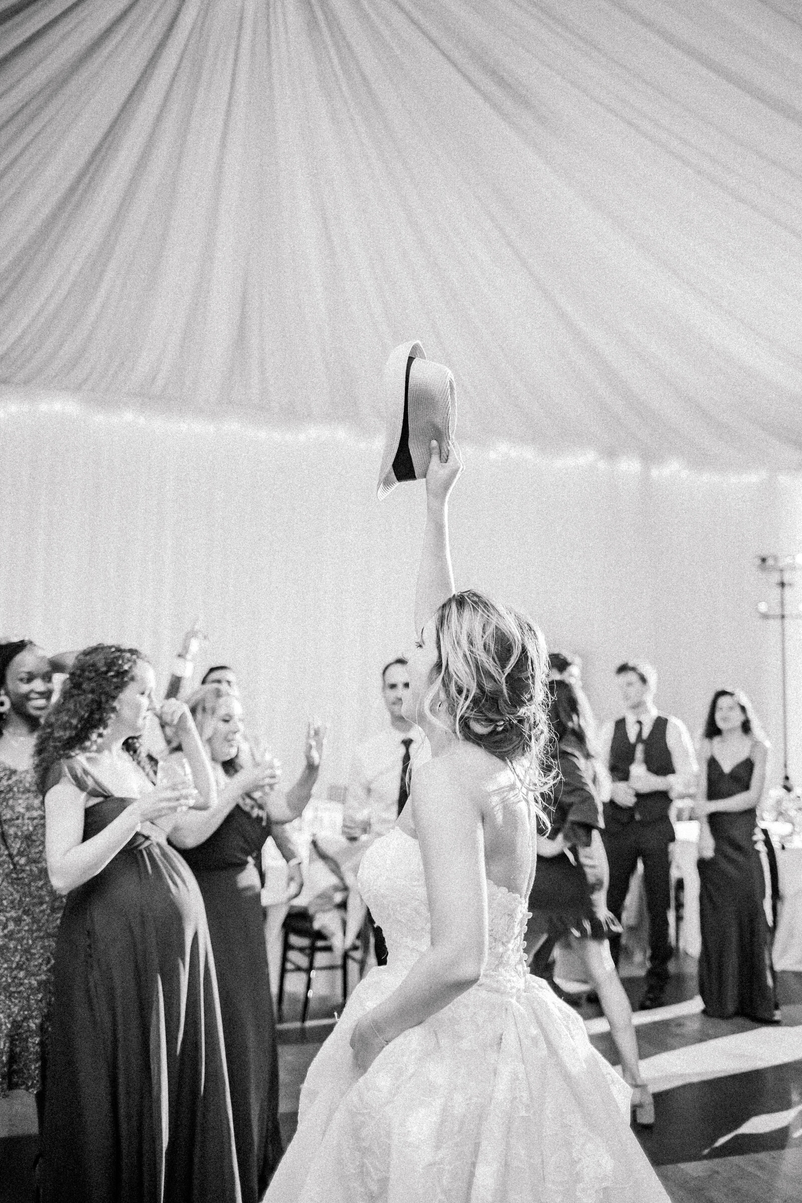 bride raising a fedora up in the air during fun dancing at Veritas Vineyards